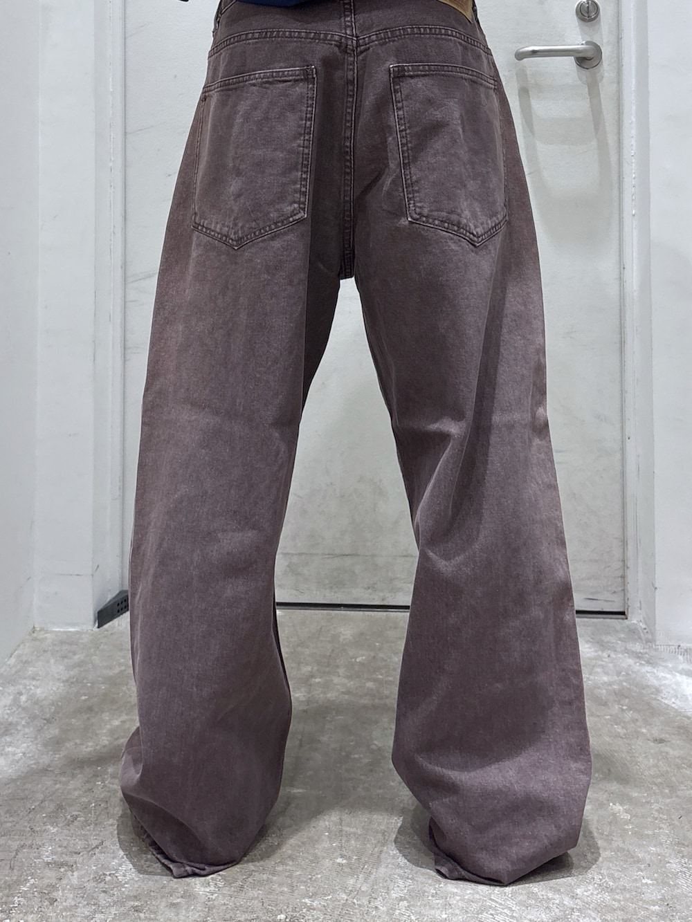 ブラウン系のデニムパンツ、ブルー系のブルゾン、ブラック系のバックパック/リュックを着用したメンズの秋コーディネートの7枚目の写真