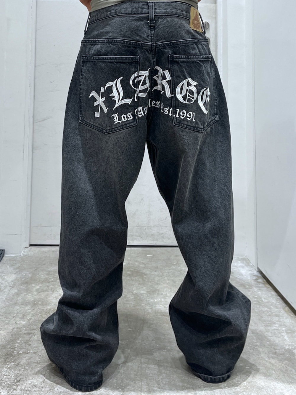 グリーン系のTシャツ/カットソー、ブラック系のデニムパンツ、ホワイト系のキャップを着用したメンズの夏コーディネートの3枚目の写真