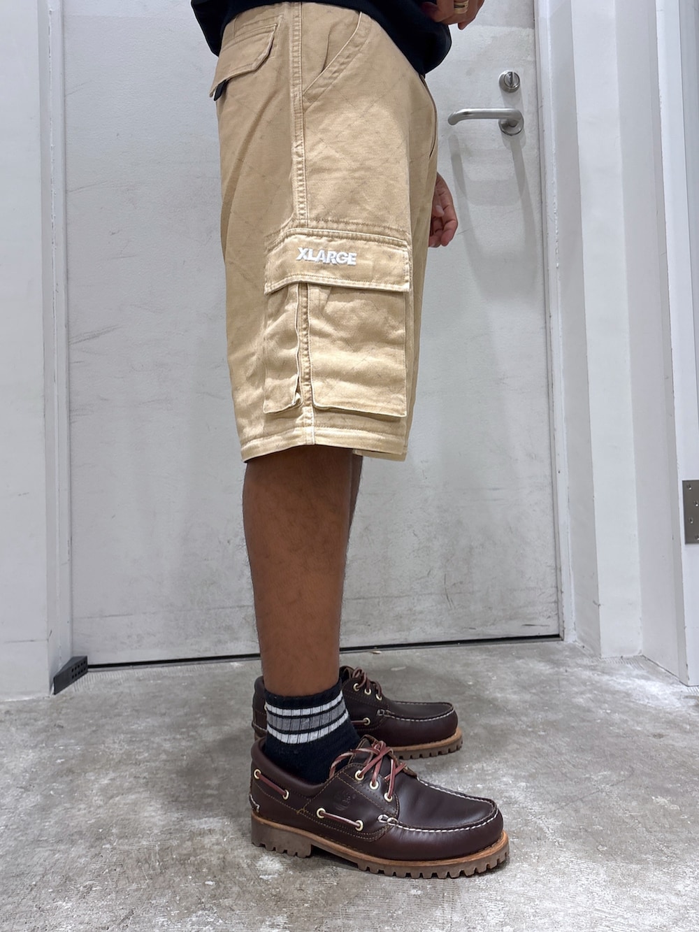 ブラック系のスウェット、ベージュ系のカーゴパンツ、ブルー系のキャップを着用したメンズの秋コーディネートの6枚目の写真