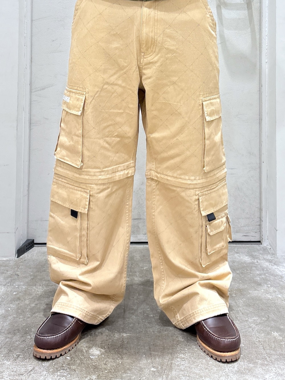 ベージュ系のカーゴパンツ、グリーン系のパーカー、ベージュ系のキャップを着用したメンズの秋コーディネートの5枚目の写真
