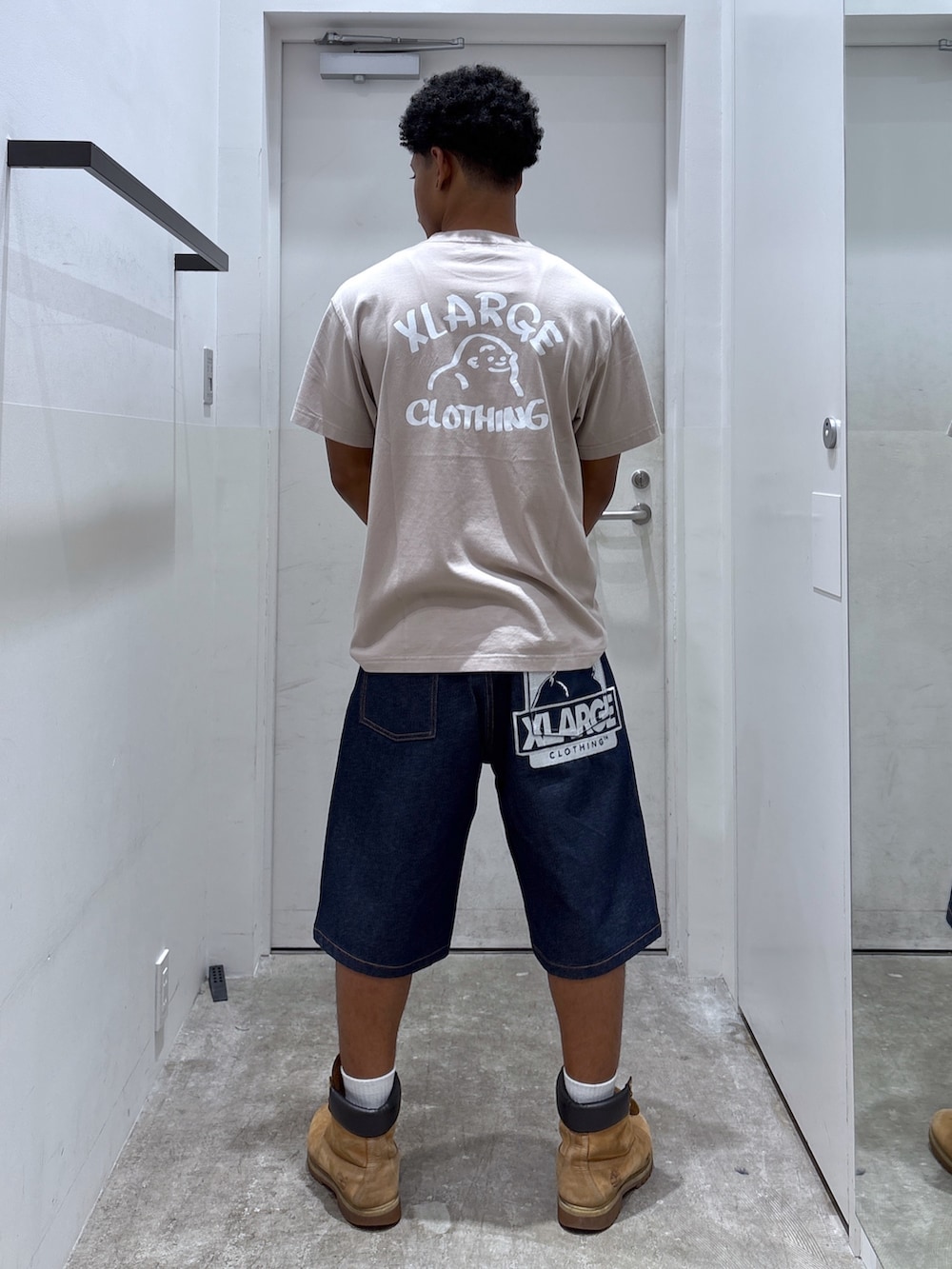 ベージュ系のTシャツ/カットソー、ブルー系のデニムパンツ、ホワイト系のコインケースを着用したメンズの夏コーディネートの2枚目の写真