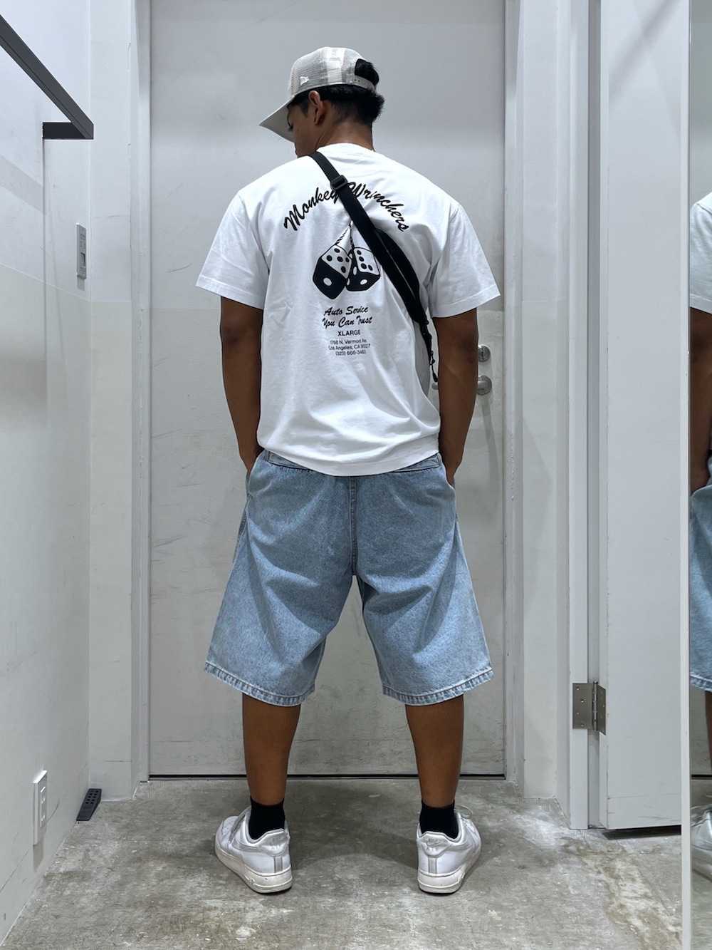 ホワイト系のTシャツ/カットソー、ブラック系のショルダーバッグ、ブルー系のデニムパンツを着用したメンズの夏コーディネートの2枚目の写真