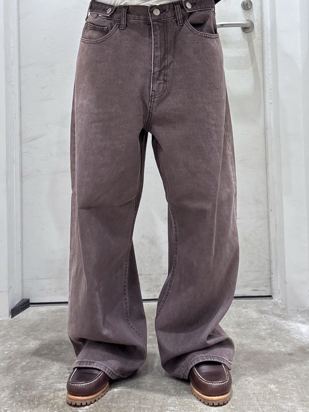 ブラウン系のデニムパンツ、ブルー系のブルゾン、ブラック系のバックパック/リュックを着用したメンズの秋コーディネートの6枚目の写真