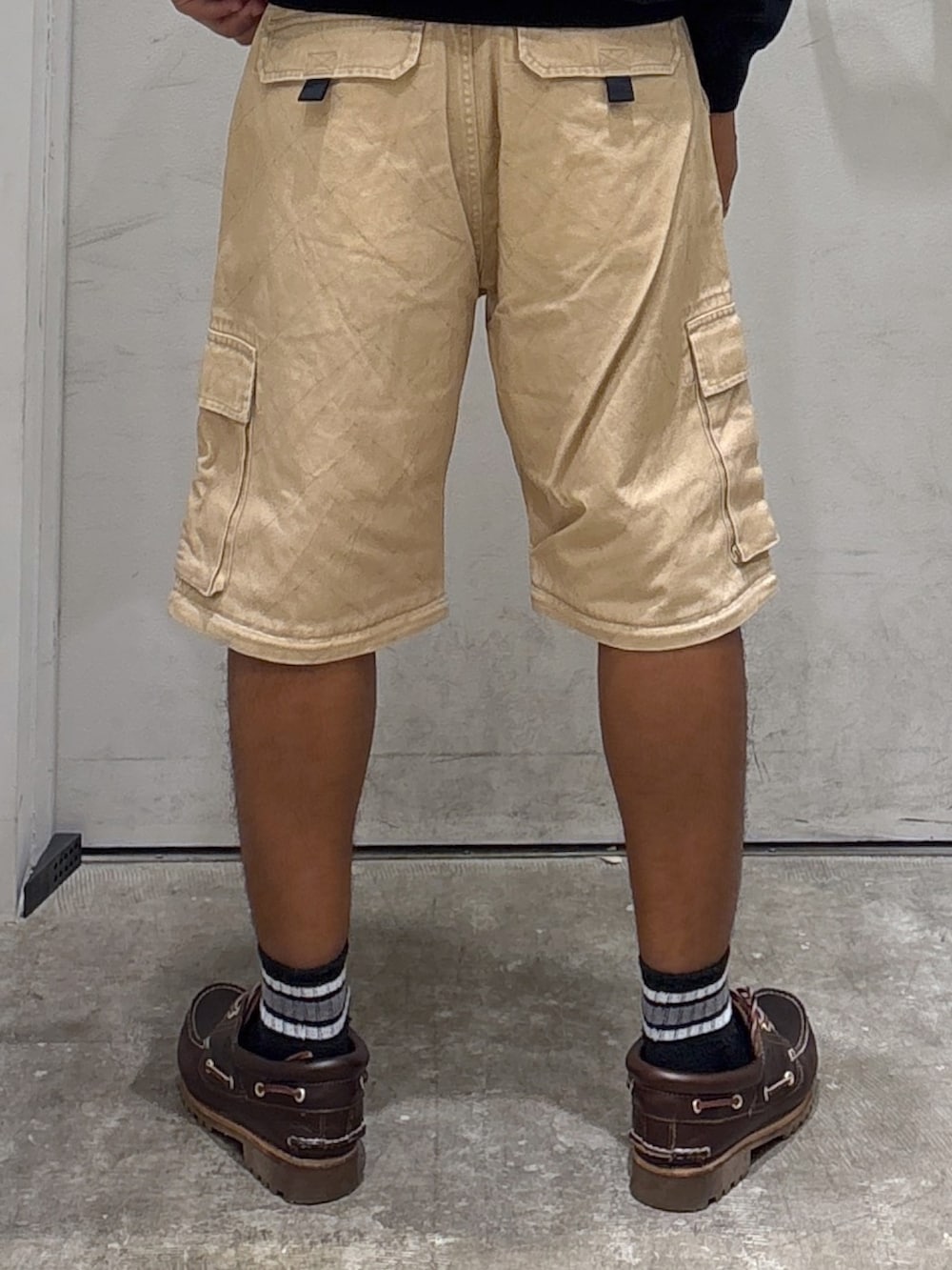 ブラック系のスウェット、ベージュ系のカーゴパンツ、ブルー系のキャップを着用したメンズの秋コーディネートの7枚目の写真