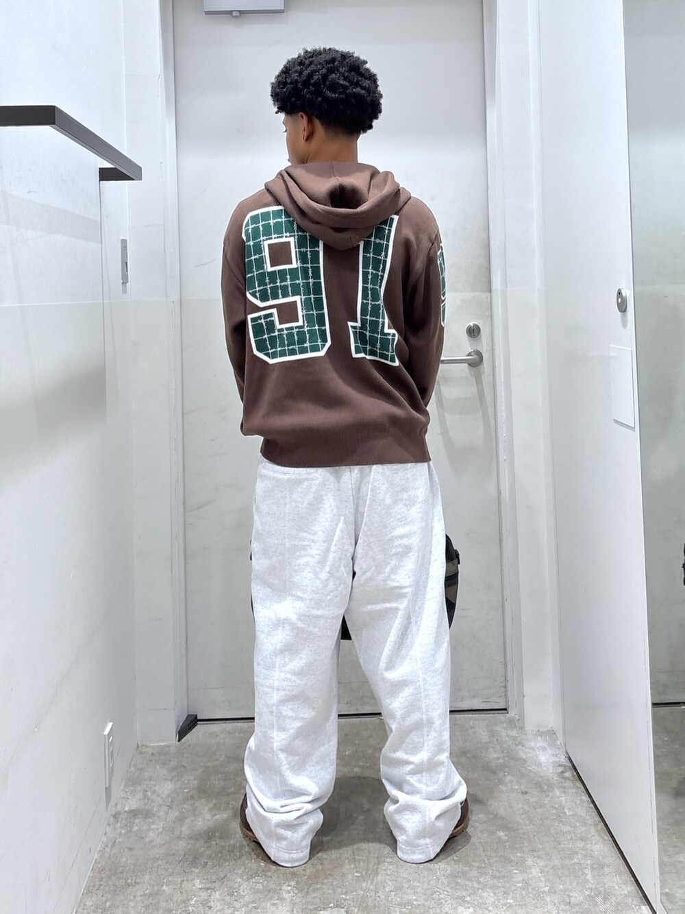 グレー系のスウェットパンツ、ブラウン系のニット/セーター、その他のショルダーバッグを着用したメンズの秋コーディネートの2枚目の写真