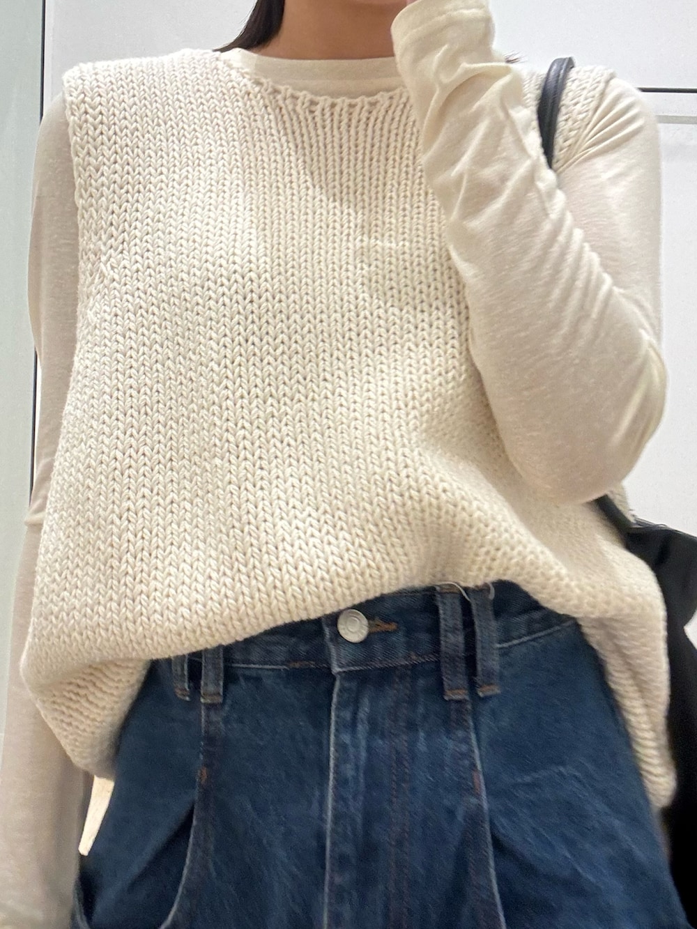 ブルー系のデニムパンツ、ホワイト系のTシャツ/カットソー、ホワイト系のベストを着用したレディースの春コーディネートの2枚目の写真