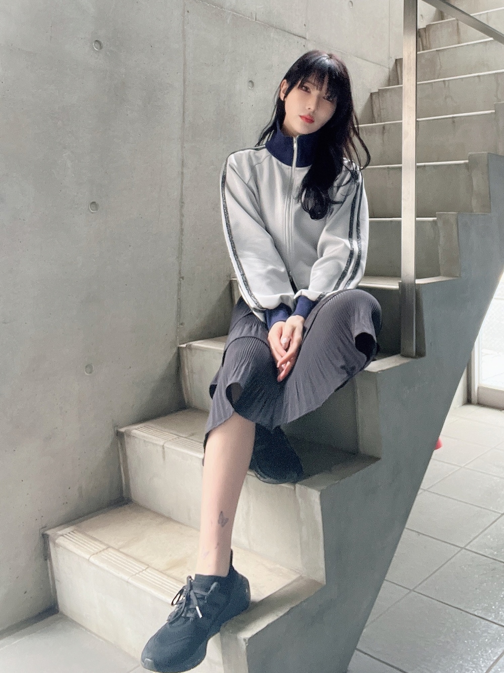 ブルー系のジャケット/アウター、ブラック系のスカート、ブラック系のスニーカーを着用したレディースの春コーディネートの3枚目の写真