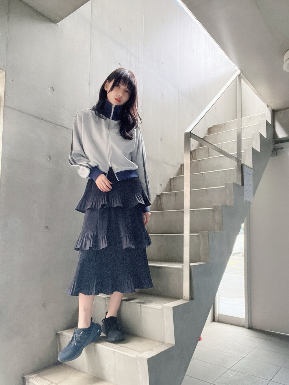 ブルー系のジャケット/アウター、ブラック系のスカート、ブラック系のスニーカーを着用したレディースの春コーディネートの2枚目の写真