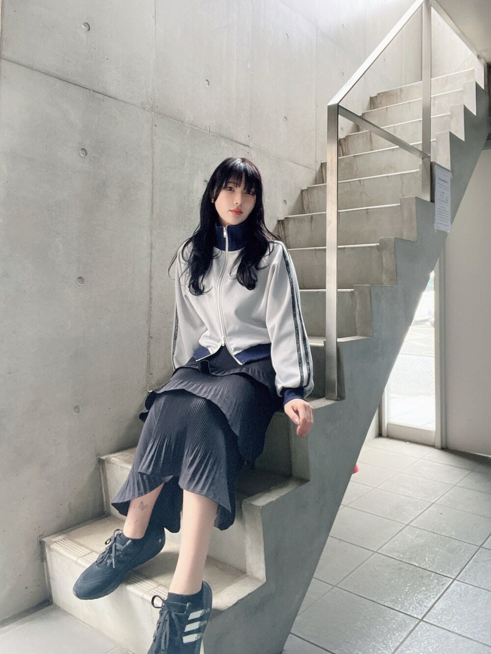 ブルー系のジャケット/アウター、ブラック系のスカート、ブラック系のスニーカーを着用したレディースの春コーディネートの4枚目の写真