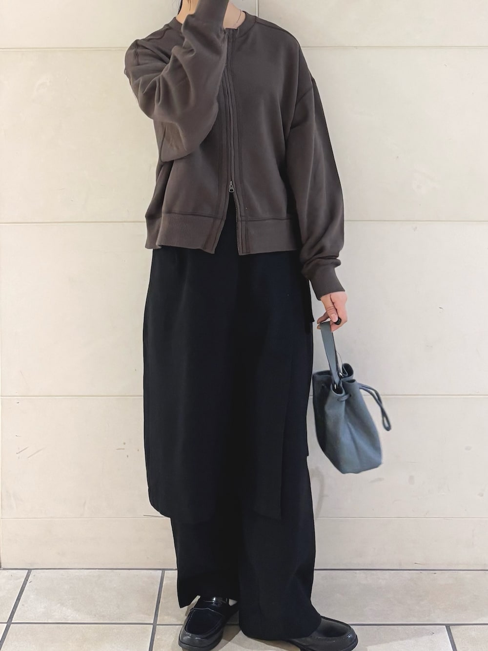 ブラウン系のカーディガン/ボレロ、ブラック系のその他パンツ、ブルー系のショルダーバッグを着用したレディースの秋コーディネートの3枚目の写真