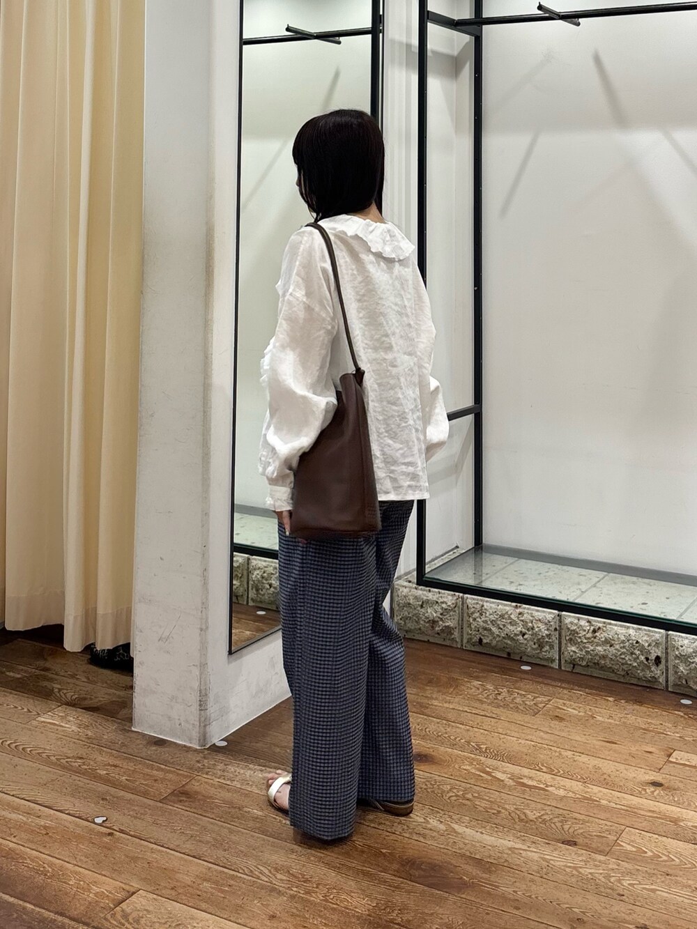 ブルー系のその他パンツ、ホワイト系のシャツ/ブラウス、ブラウン系のショルダーバッグを着用したレディースの夏コーディネートの2枚目の写真