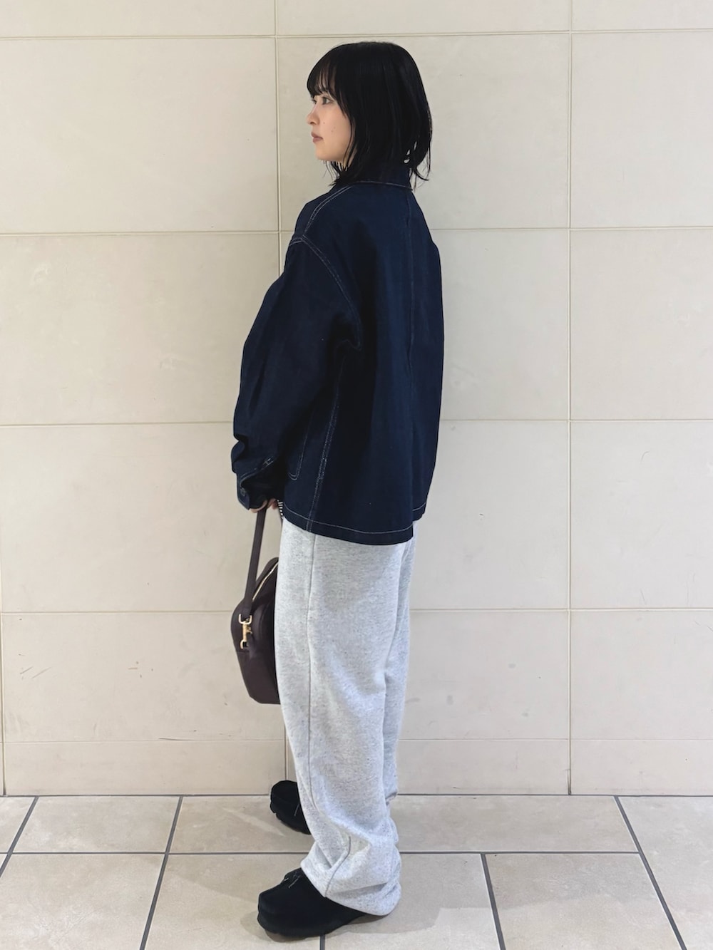 グレー系のその他パンツ、レッド系のショルダーバッグ、ブラック系のTシャツ/カットソーを着用したレディースの秋コーディネートの2枚目の写真