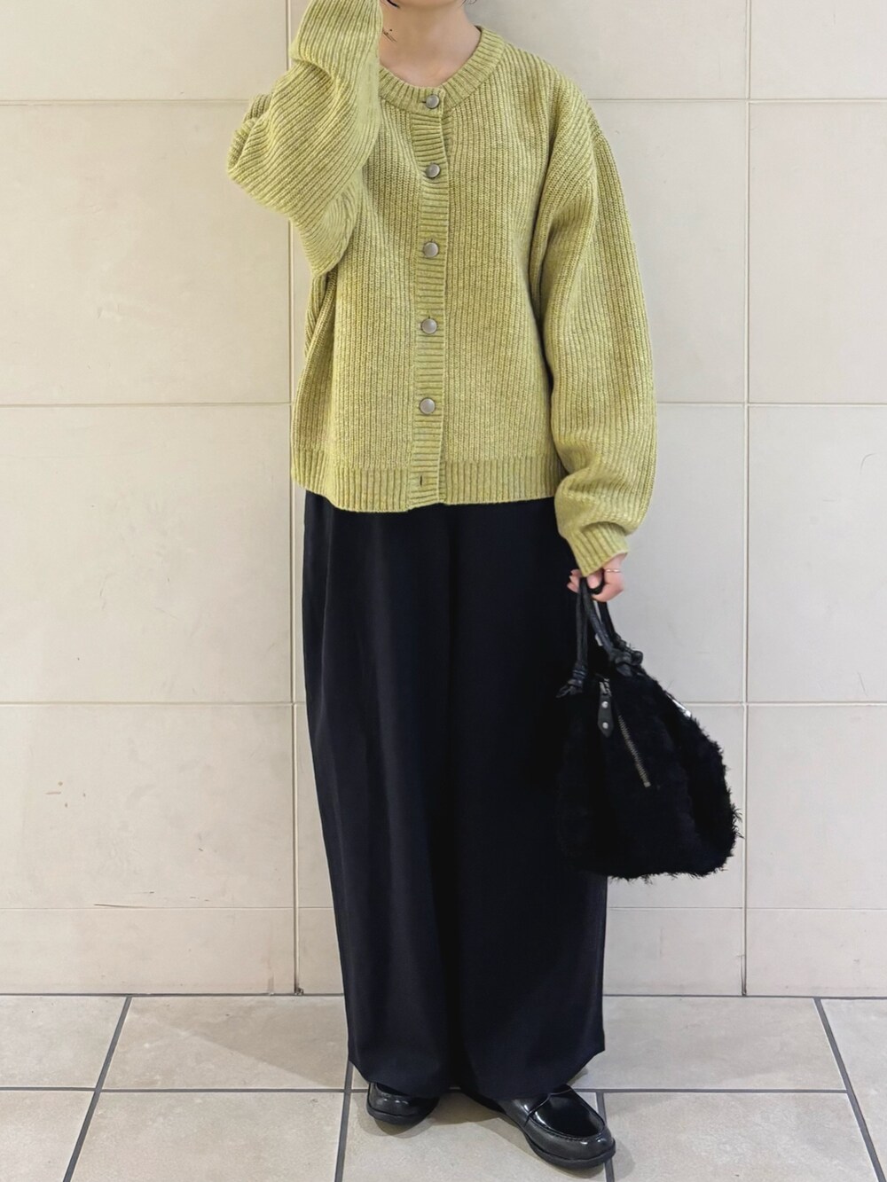 ブルー系のその他パンツ、ブラック系のハンドバッグ、グリーン系のカーディガン/ボレロを着用したレディースの秋コーディネートの2枚目の写真