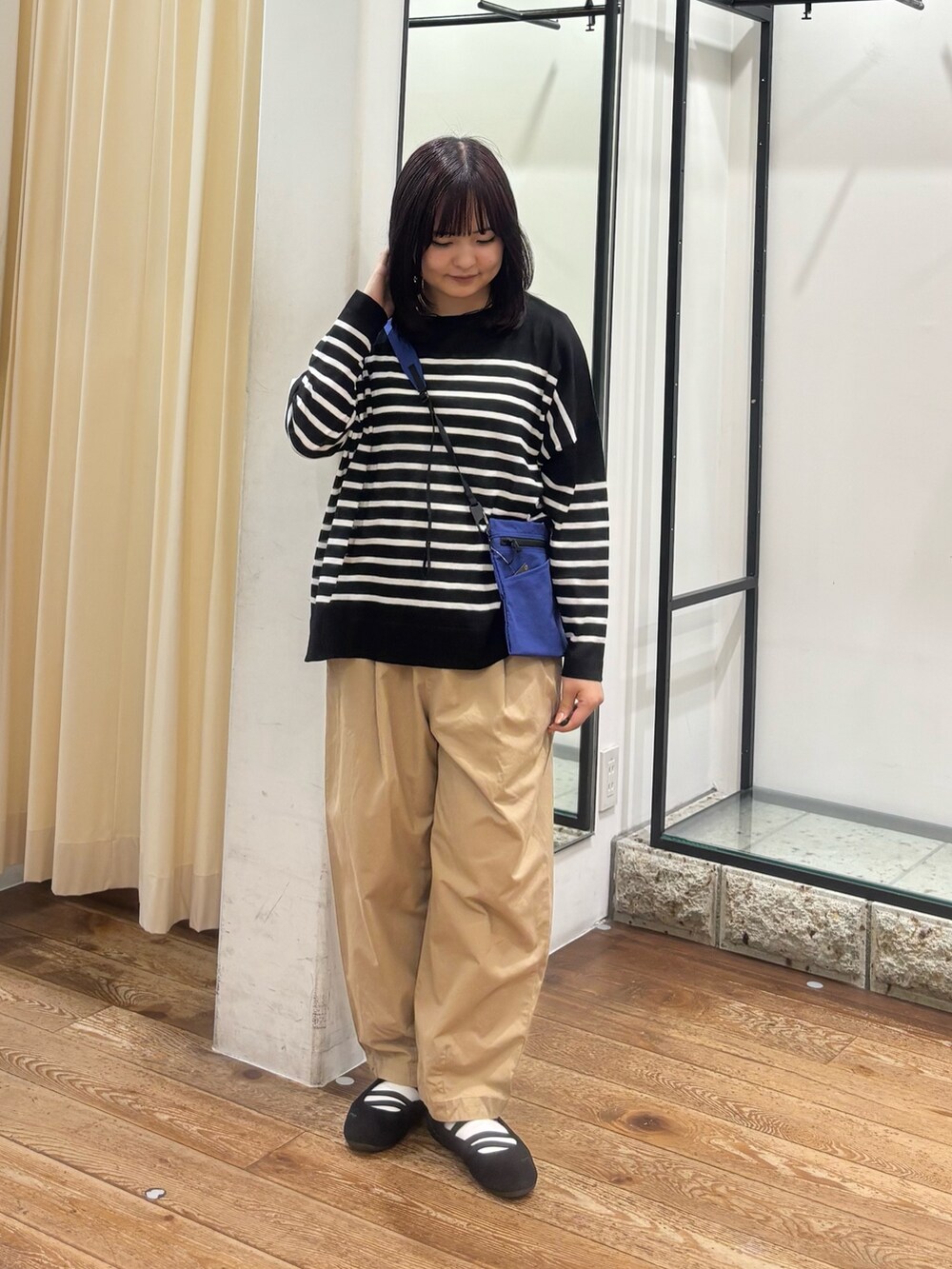 ベージュ系のその他パンツ、ブルー系のショルダーバッグ、ブラック系のニット/セーターを着用したレディースの夏コーディネートの2枚目の写真
