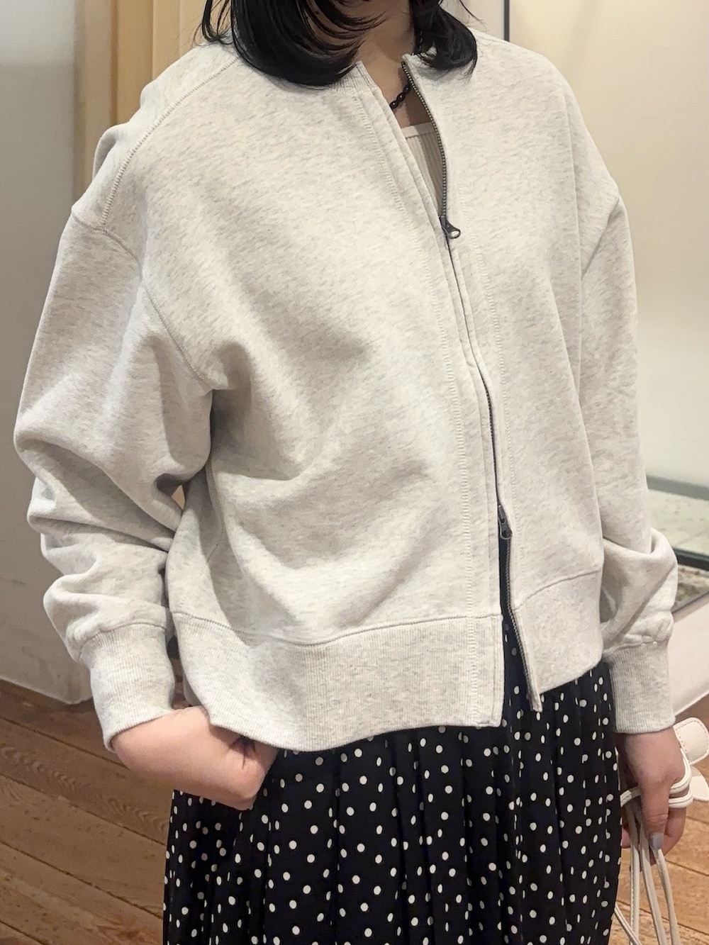 ブラック系のスカート、ホワイト系のショルダーバッグ、ブラック系のスニーカーを着用したレディースの春コーディネートの4枚目の写真