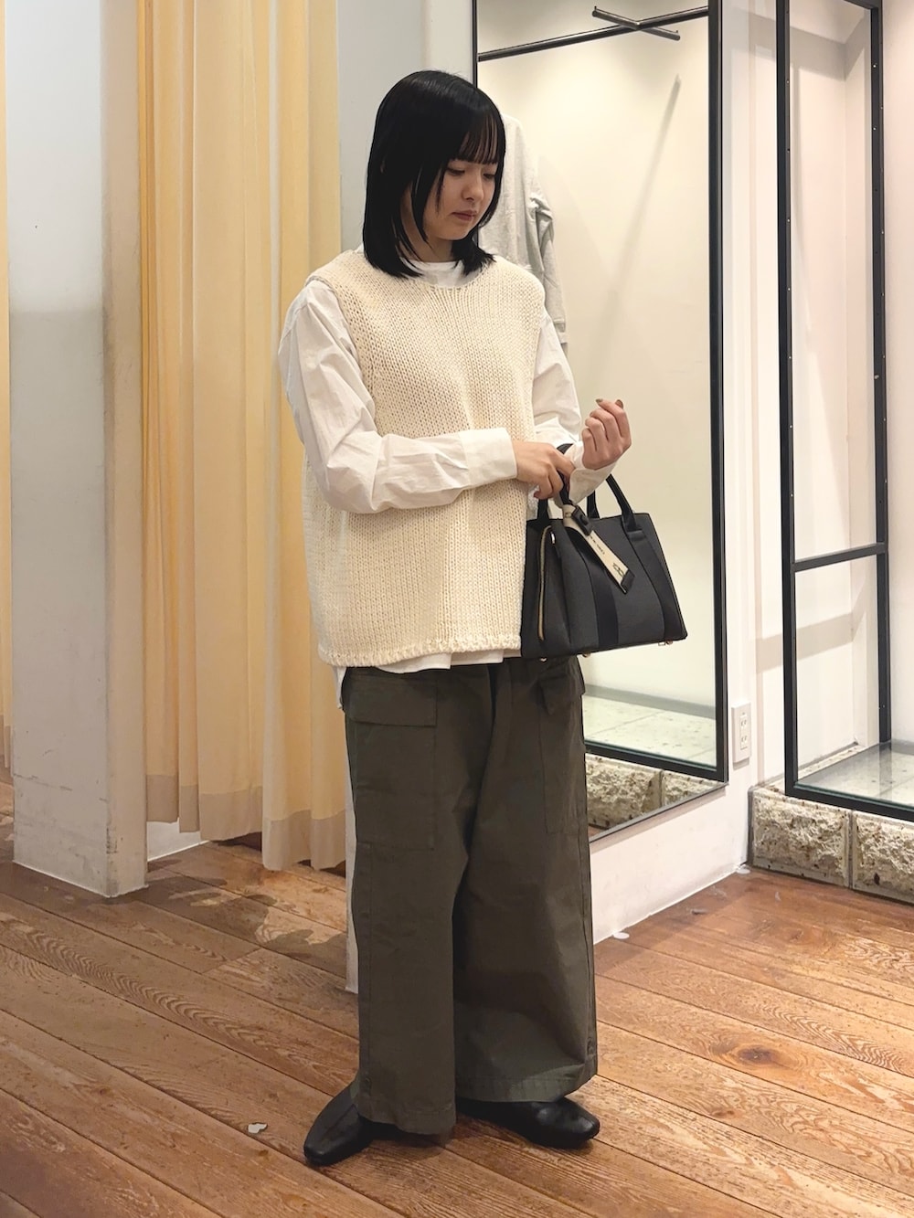 グリーン系のその他パンツ、ブラック系のハンドバッグ、ホワイト系のシャツ/ブラウスを着用したレディースの冬コーディネートの2枚目の写真