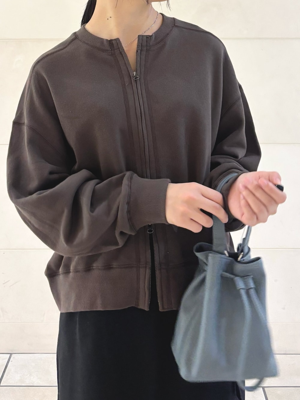 ブラウン系のカーディガン/ボレロ、ブラック系のその他パンツ、ブルー系のショルダーバッグを着用したレディースの秋コーディネートの4枚目の写真