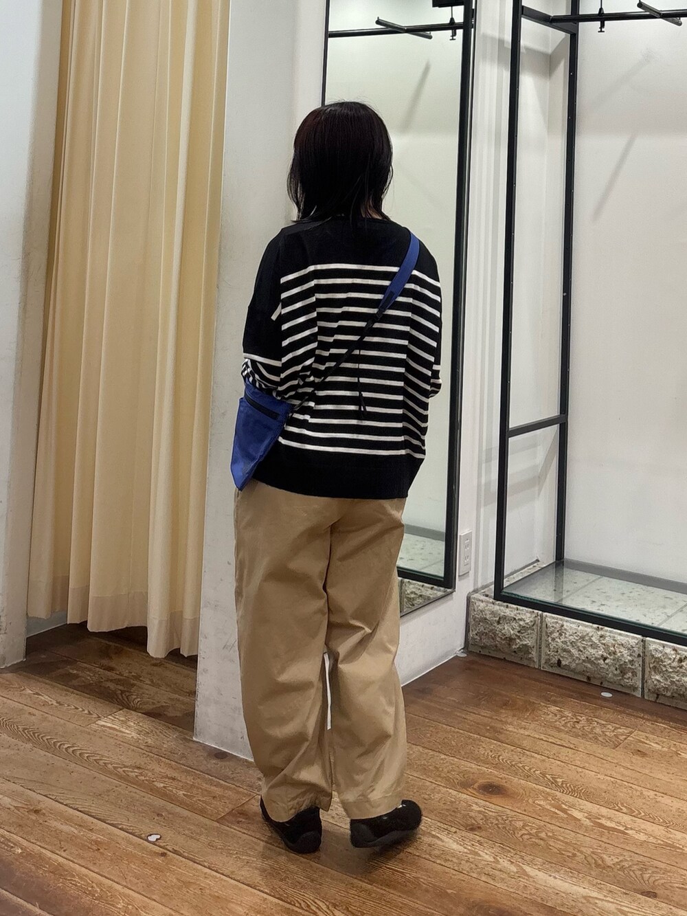 ベージュ系のその他パンツ、ブルー系のショルダーバッグ、ブラック系のニット/セーターを着用したレディースの夏コーディネートの3枚目の写真