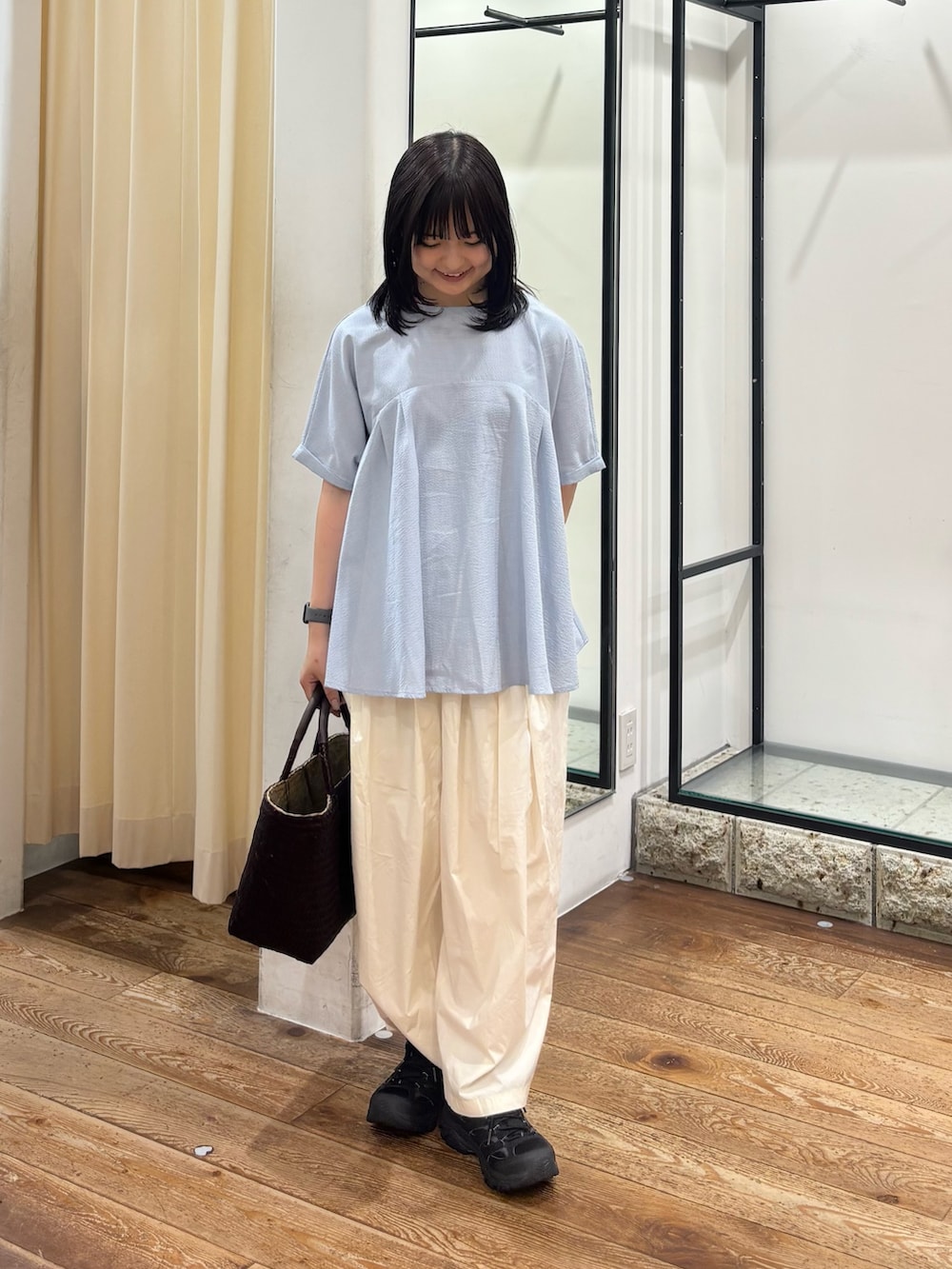 ホワイト系のその他パンツ、ブラウン系のトートバッグ、ブルー系のシャツ/ブラウスを着用したレディースの夏コーディネートの2枚目の写真