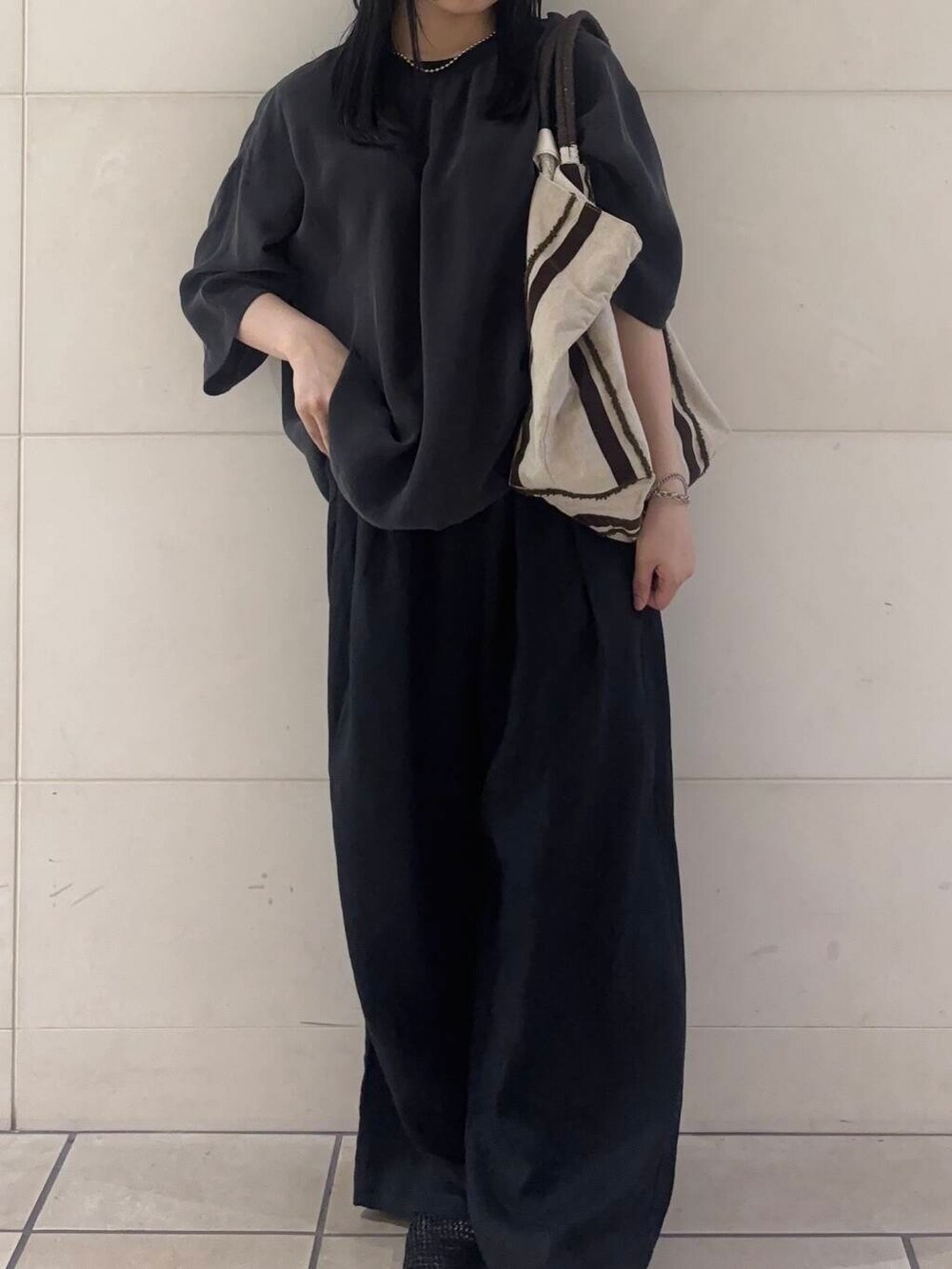 ブラック系のバレエシューズ、ブラウン系のトートバッグ、ブラック系のその他パンツを着用したレディースの夏コーディネートの2枚目の写真