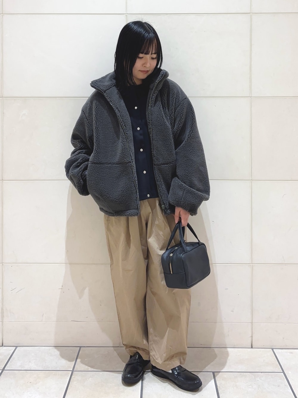 ブラック系のカーディガン/ボレロ、グレー系のその他アウター、ベージュ系のその他パンツを着用したレディースの冬コーディネートの2枚目の写真