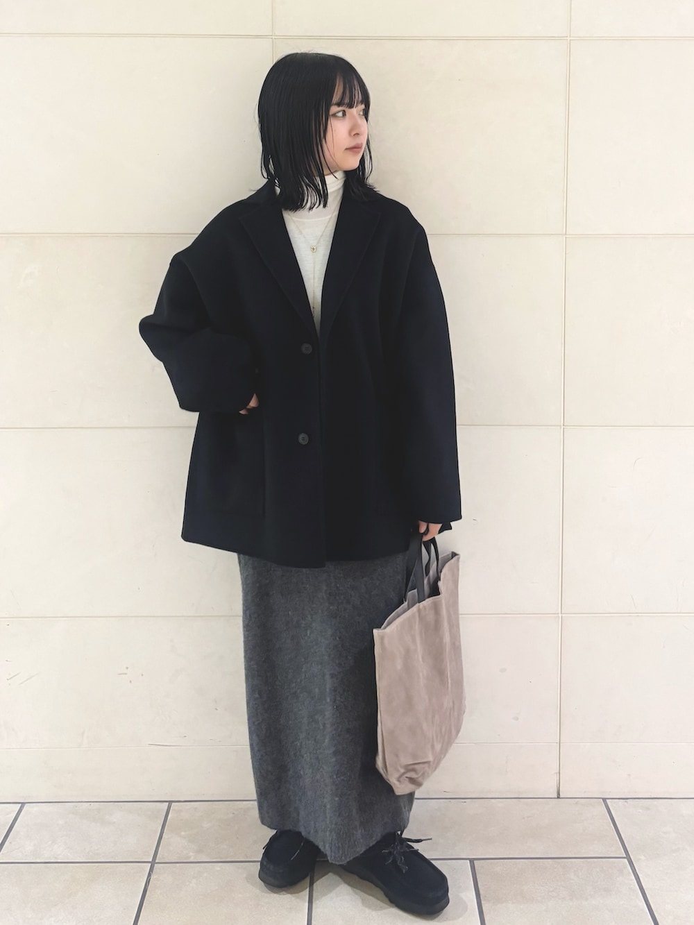 ホワイト系のニット/セーター、グレー系のワンピース、グレー系のトートバッグを着用したレディースの冬コーディネートの2枚目の写真