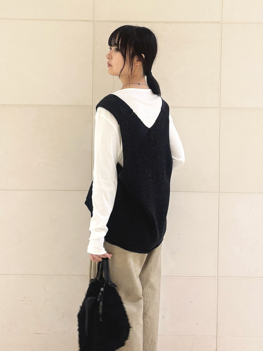 ブラック系のニット/セーター、グリーン系のTシャツ/カットソー、ベージュ系のその他パンツを着用したレディースの秋コーディネートの3枚目の写真