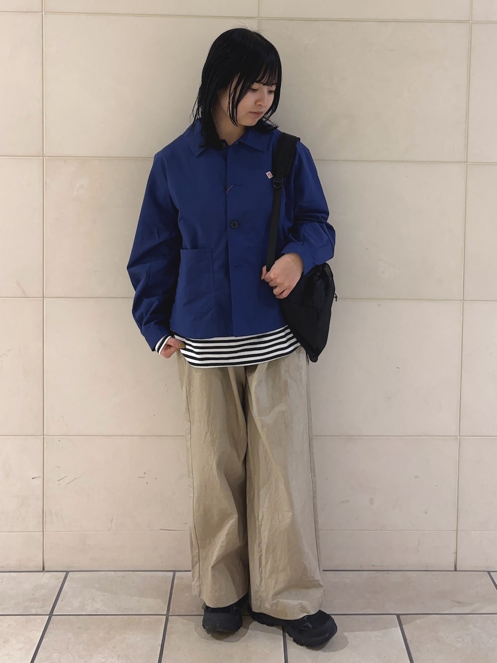 ホワイト系のTシャツ/カットソー、ベージュ系のその他パンツ、ブラック系のバックパック/リュックを着用したレディースの冬コーディネートの2枚目の写真