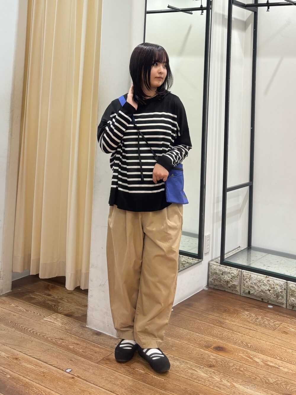 ベージュ系のその他パンツ、ブルー系のショルダーバッグ、ブラック系のニット/セーターを着用したレディースの夏コーディネートの4枚目の写真