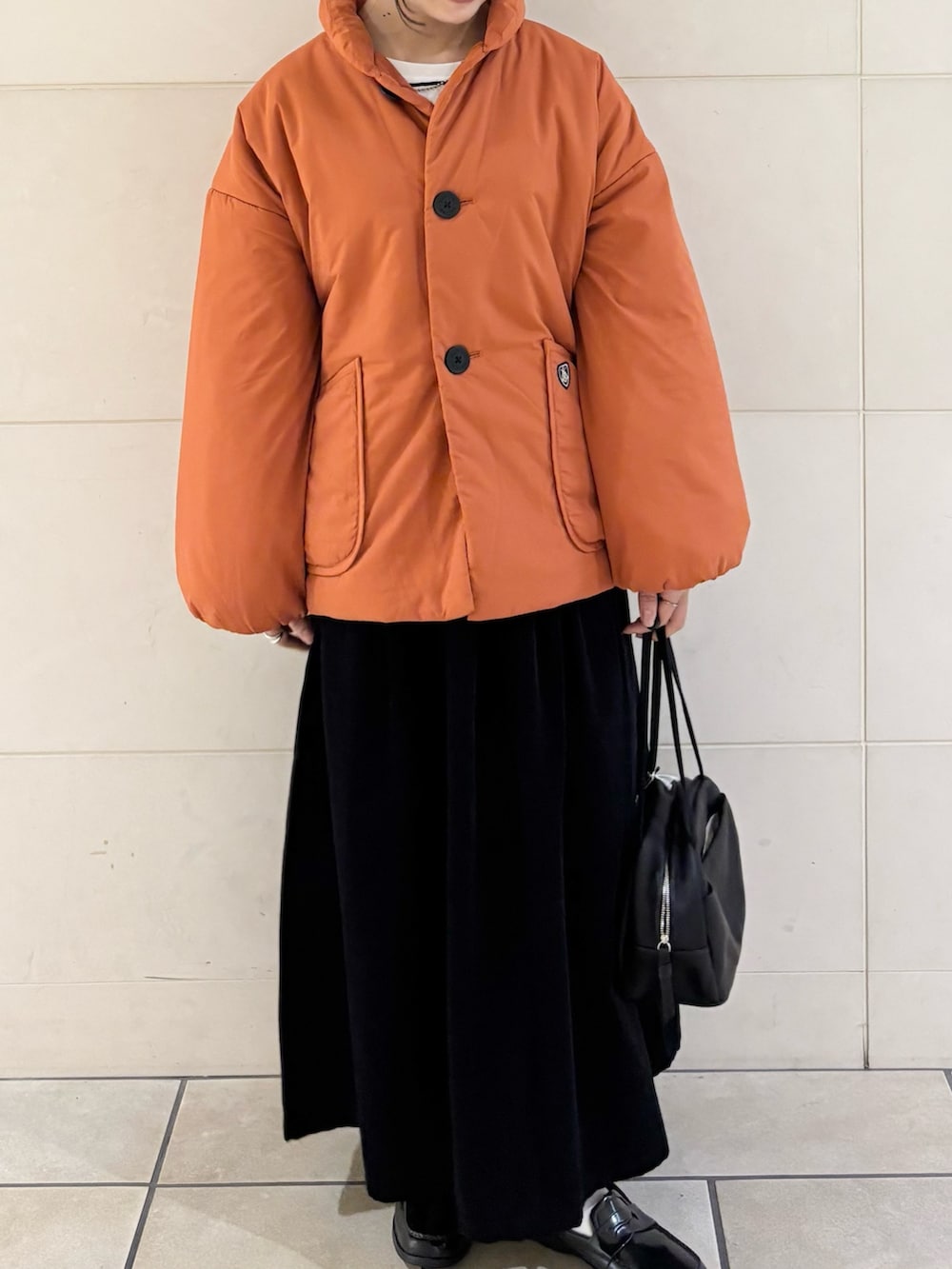 オレンジ系のブルゾン、グレー系のスカート、ブラック系のボストンバッグを着用したレディースの秋コーディネートの2枚目の写真