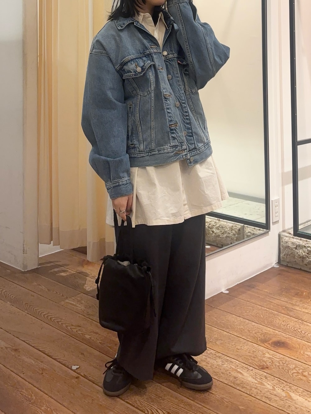 ブルー系のデニムジャケット、ホワイト系のシャツ/ブラウス、グレー系のその他パンツを着用したレディースの冬コーディネートの2枚目の写真