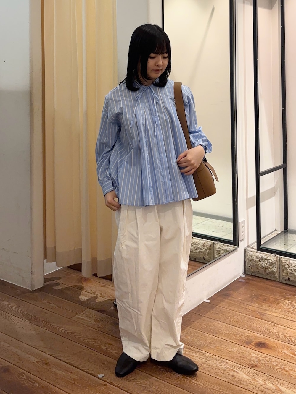 イエロー系のショルダーバッグ、ブルー系のシャツ/ブラウス、ホワイト系のその他パンツを着用したレディースの春コーディネートの2枚目の写真