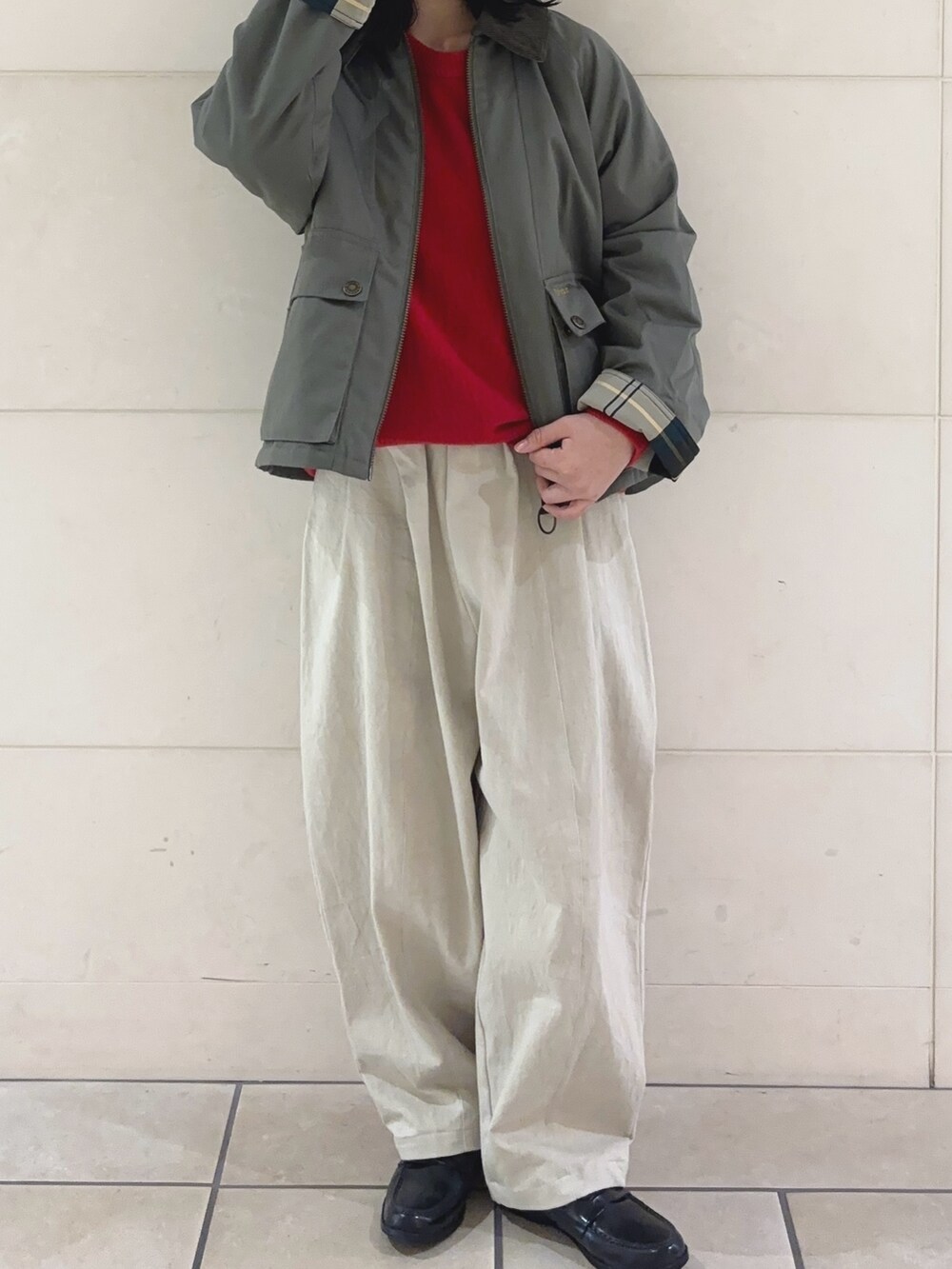 レッド系のニット/セーター、グリーン系のブルゾン、ホワイト系のその他パンツを着用したレディースの冬コーディネートの2枚目の写真