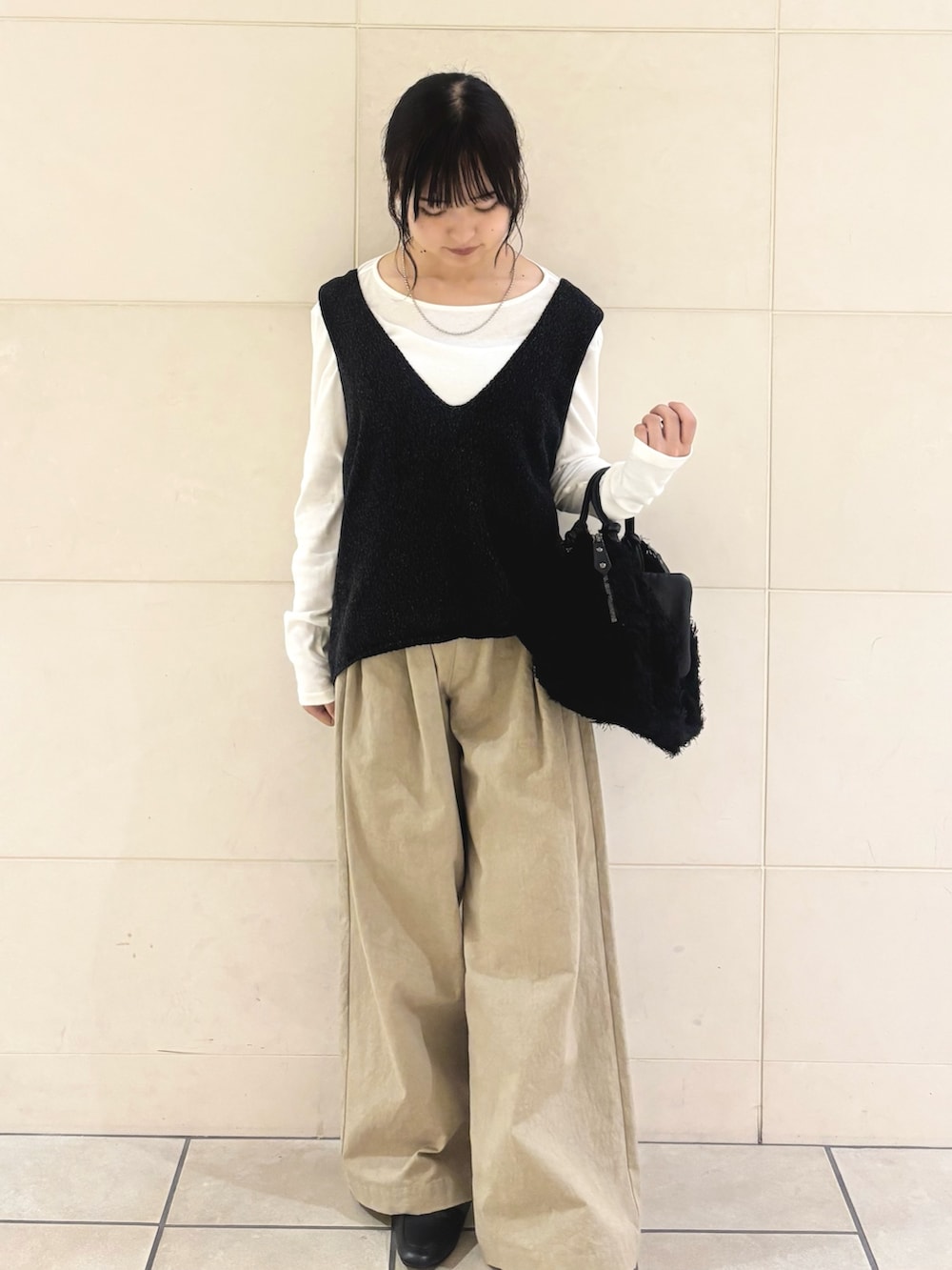 ブラック系のニット/セーター、グリーン系のTシャツ/カットソー、ベージュ系のその他パンツを着用したレディースの秋コーディネートの2枚目の写真