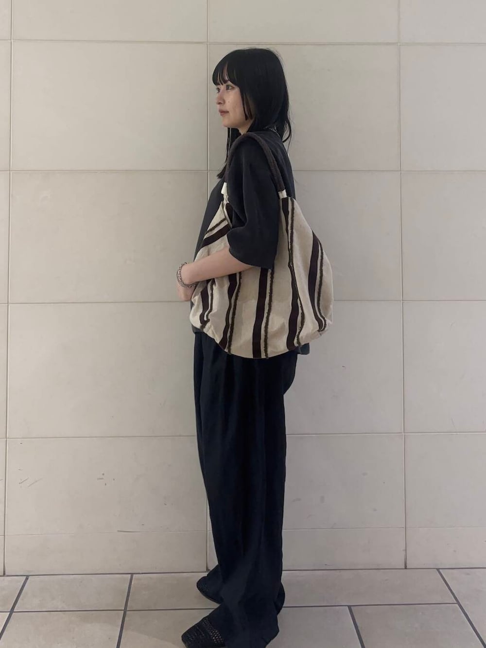 ブラック系のバレエシューズ、ブラウン系のトートバッグ、ブラック系のその他パンツを着用したレディースの夏コーディネートの3枚目の写真