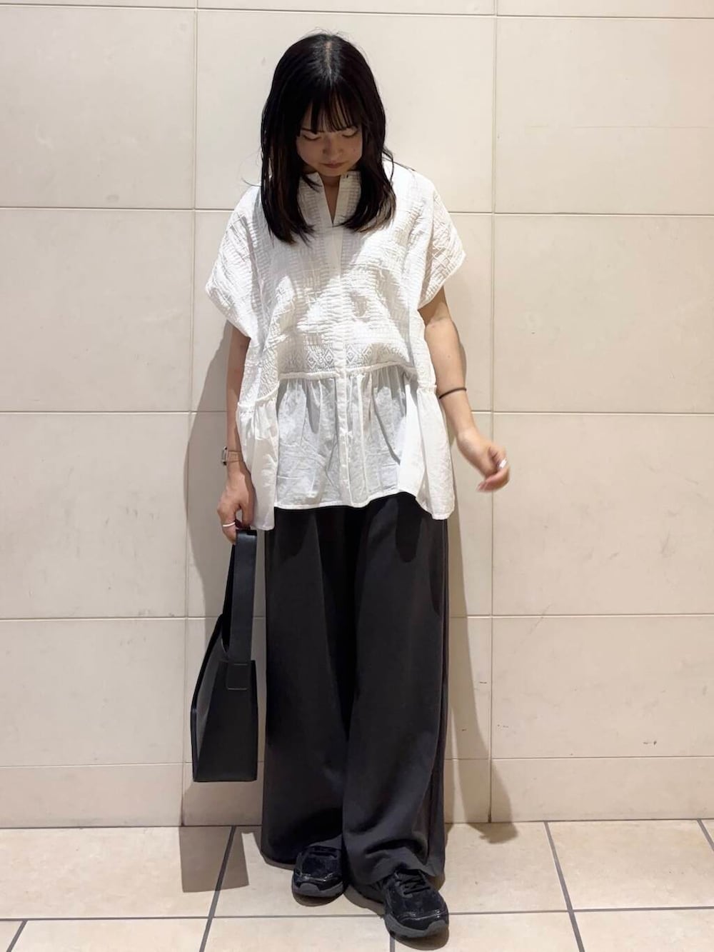 ブラック系のスニーカー、ホワイト系のシャツ/ブラウスを着用したレディースの夏コーディネートの3枚目の写真