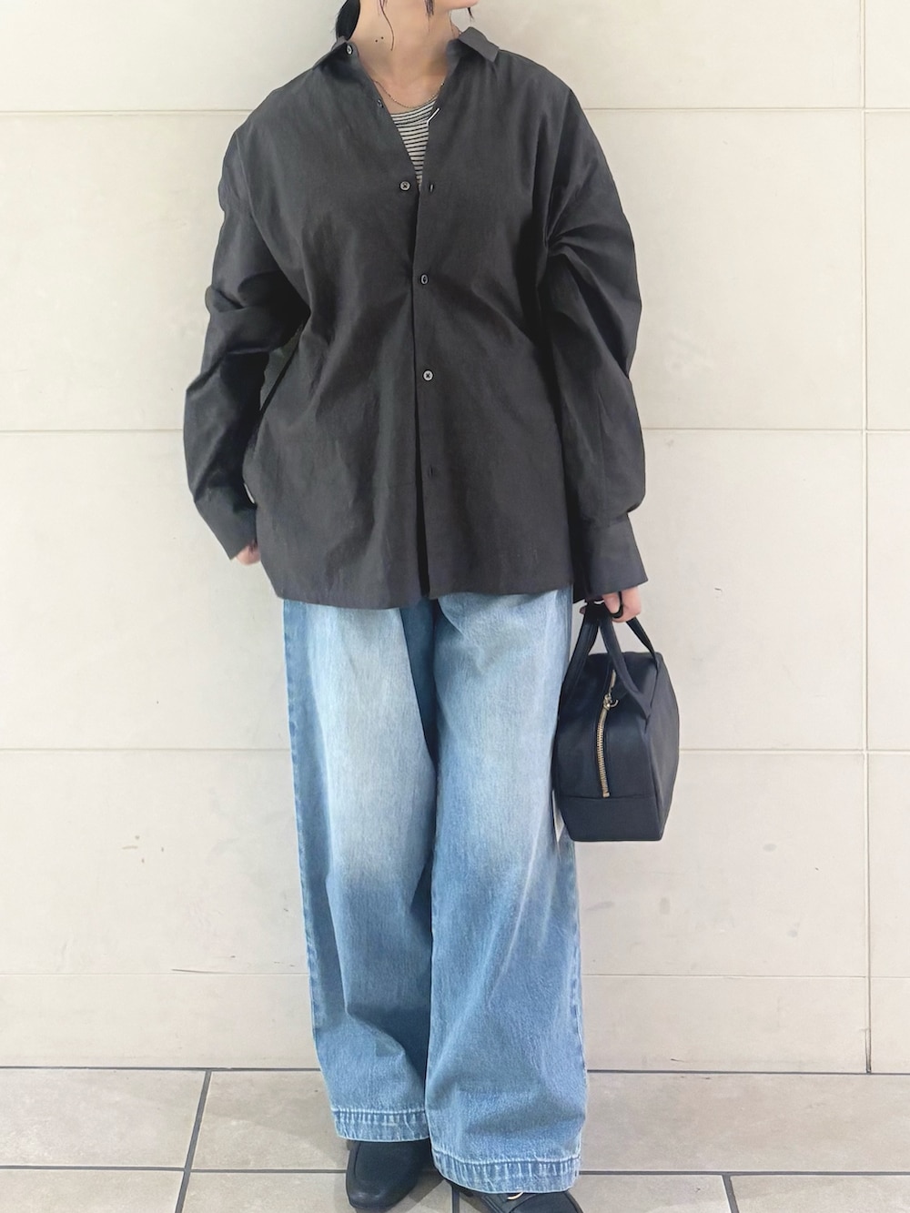 ブルー系のデニムパンツ、ブラック系のパンプスを着用したレディースの秋コーディネートの2枚目の写真