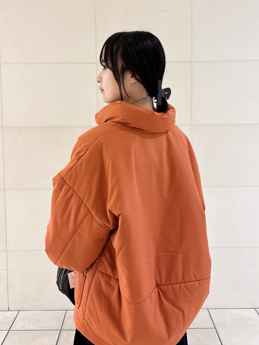 オレンジ系のブルゾン、グレー系のスカート、ブラック系のボストンバッグを着用したレディースの秋コーディネートの7枚目の写真