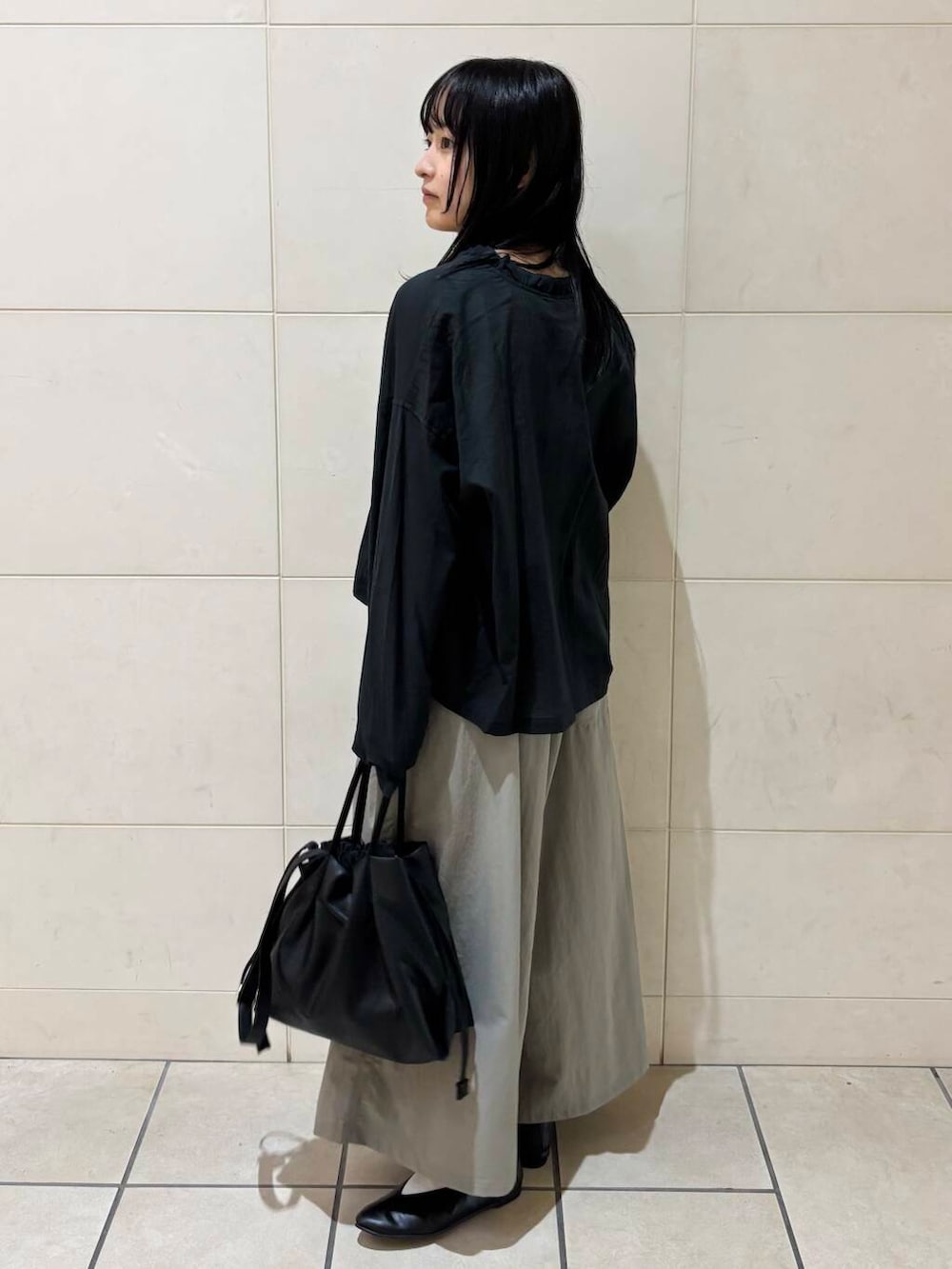 ブラック系のパンプス、ブラック系のショルダーバッグ、ホワイト系のタンクトップを着用したレディースの夏コーディネートの3枚目の写真