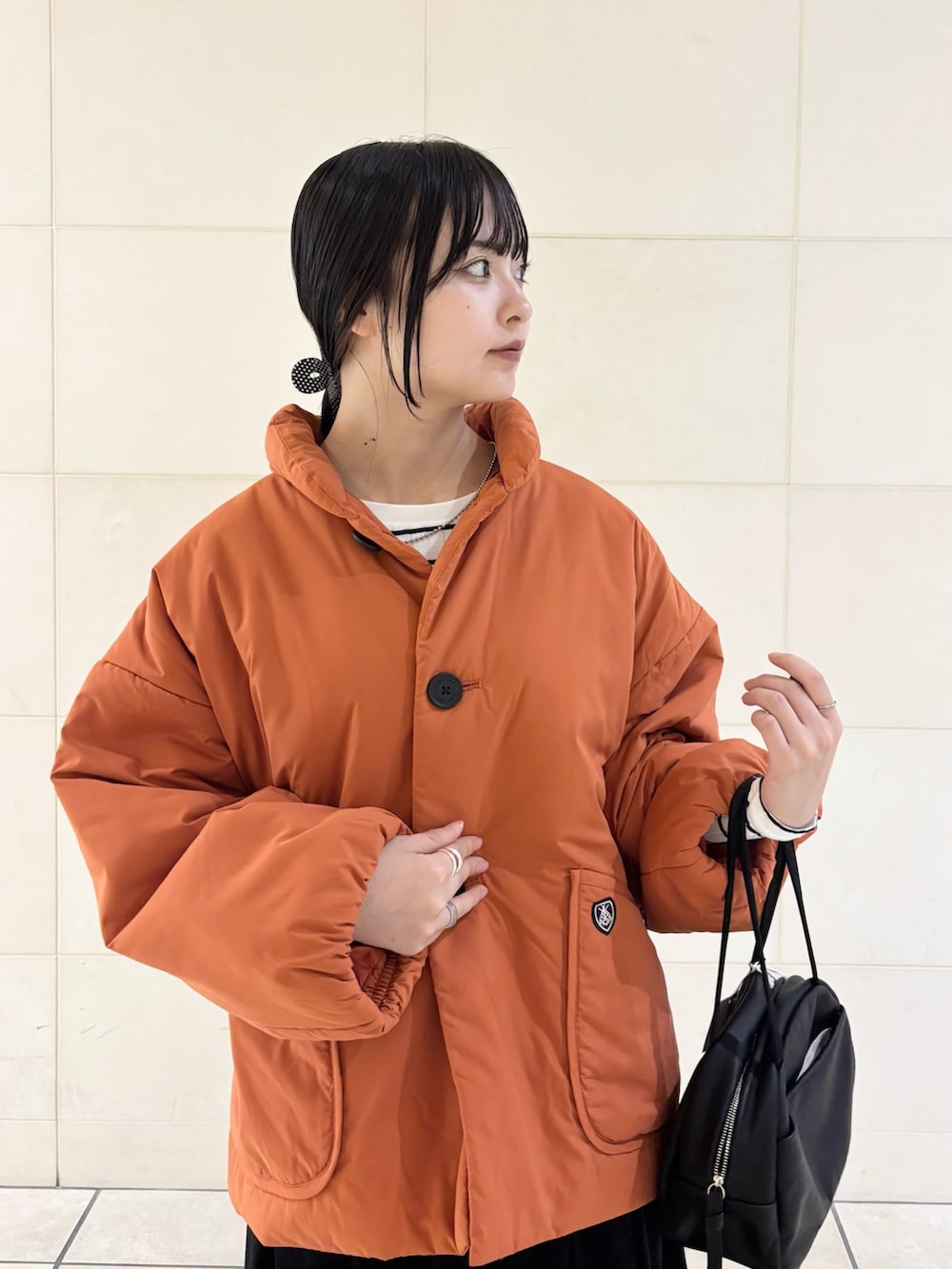 オレンジ系のブルゾン、グレー系のスカート、ブラック系のボストンバッグを着用したレディースの秋コーディネートの6枚目の写真