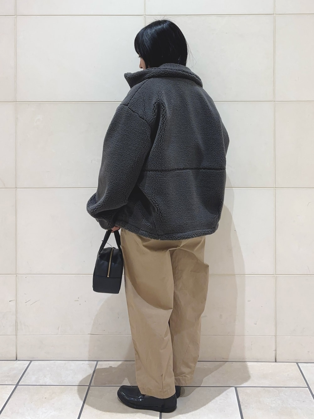 ブラック系のカーディガン/ボレロ、グレー系のその他アウター、ベージュ系のその他パンツを着用したレディースの冬コーディネートの3枚目の写真