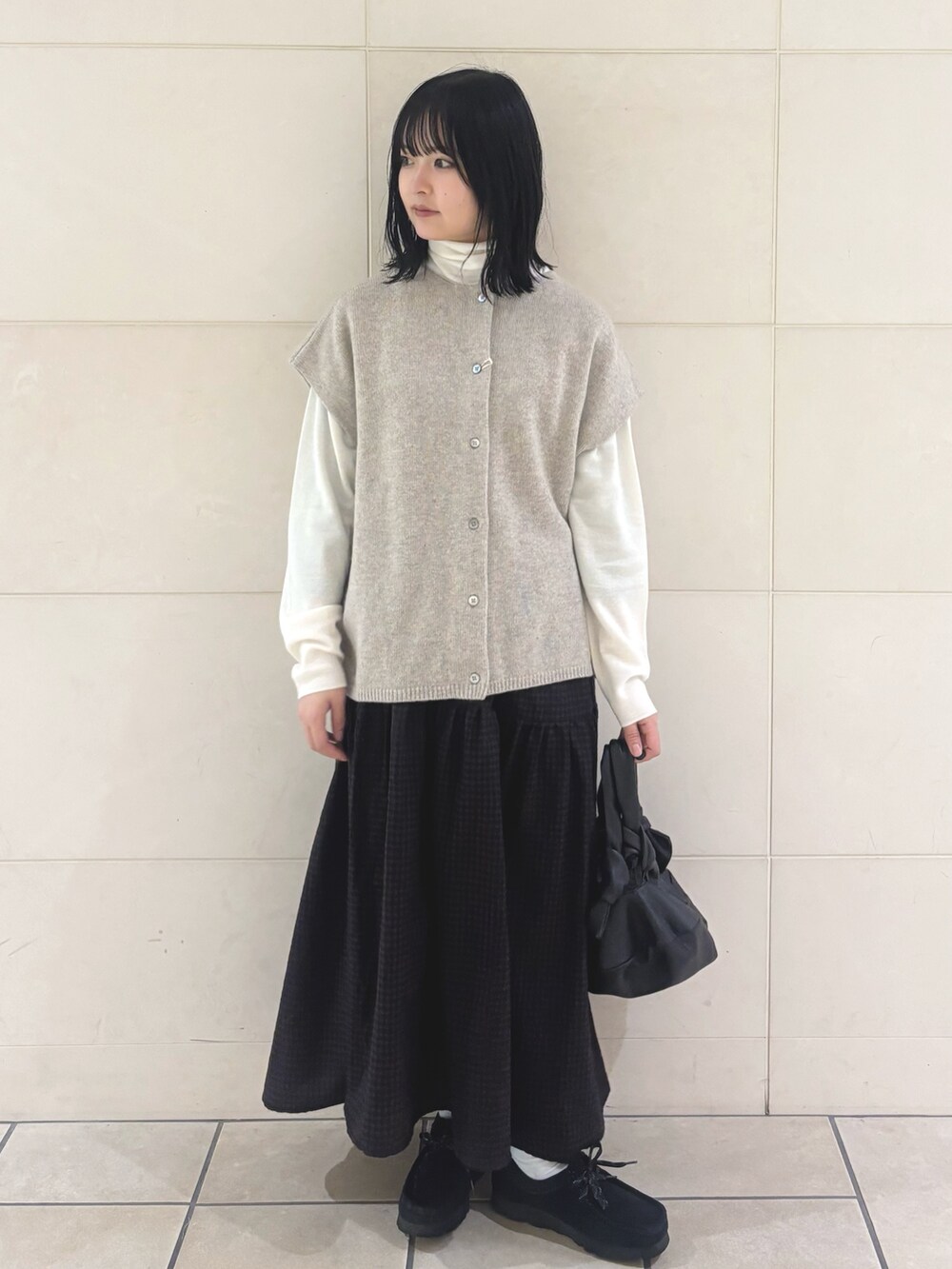 ベージュ系のニット/セーター、ホワイト系のニット/セーター、ブラウン系のスカートを着用したレディースの秋コーディネートの3枚目の写真