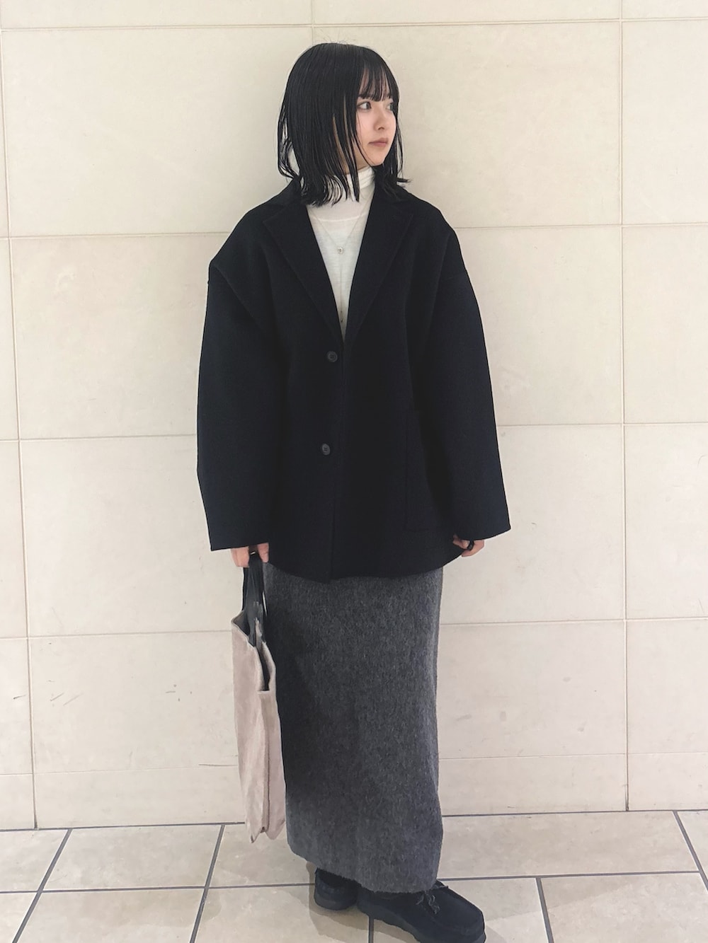 ホワイト系のニット/セーター、グレー系のワンピース、グレー系のトートバッグを着用したレディースの冬コーディネートの5枚目の写真