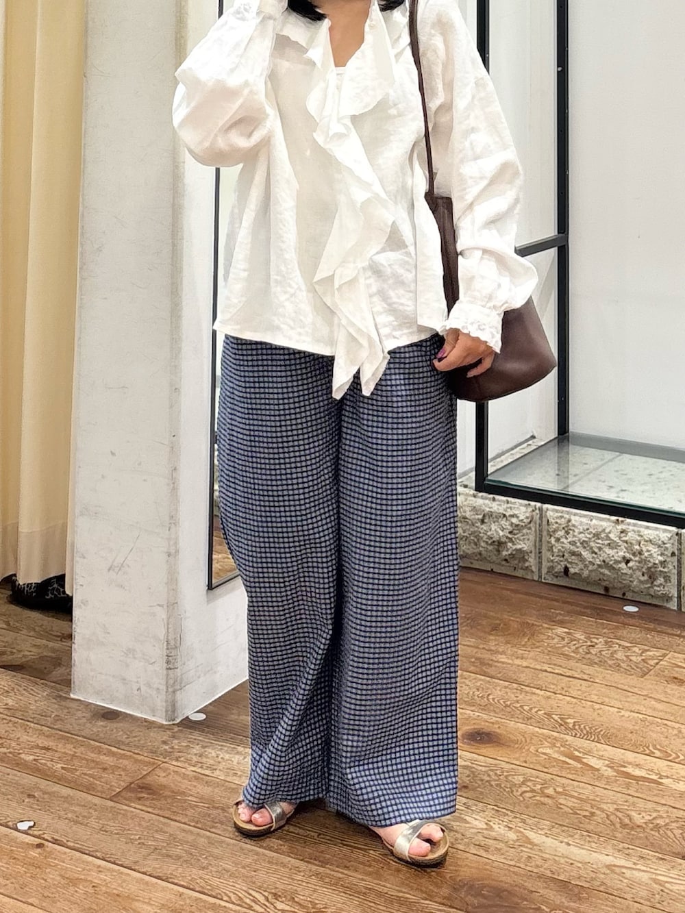 ブルー系のその他パンツ、ホワイト系のシャツ/ブラウス、ブラウン系のショルダーバッグを着用したレディースの夏コーディネートの3枚目の写真