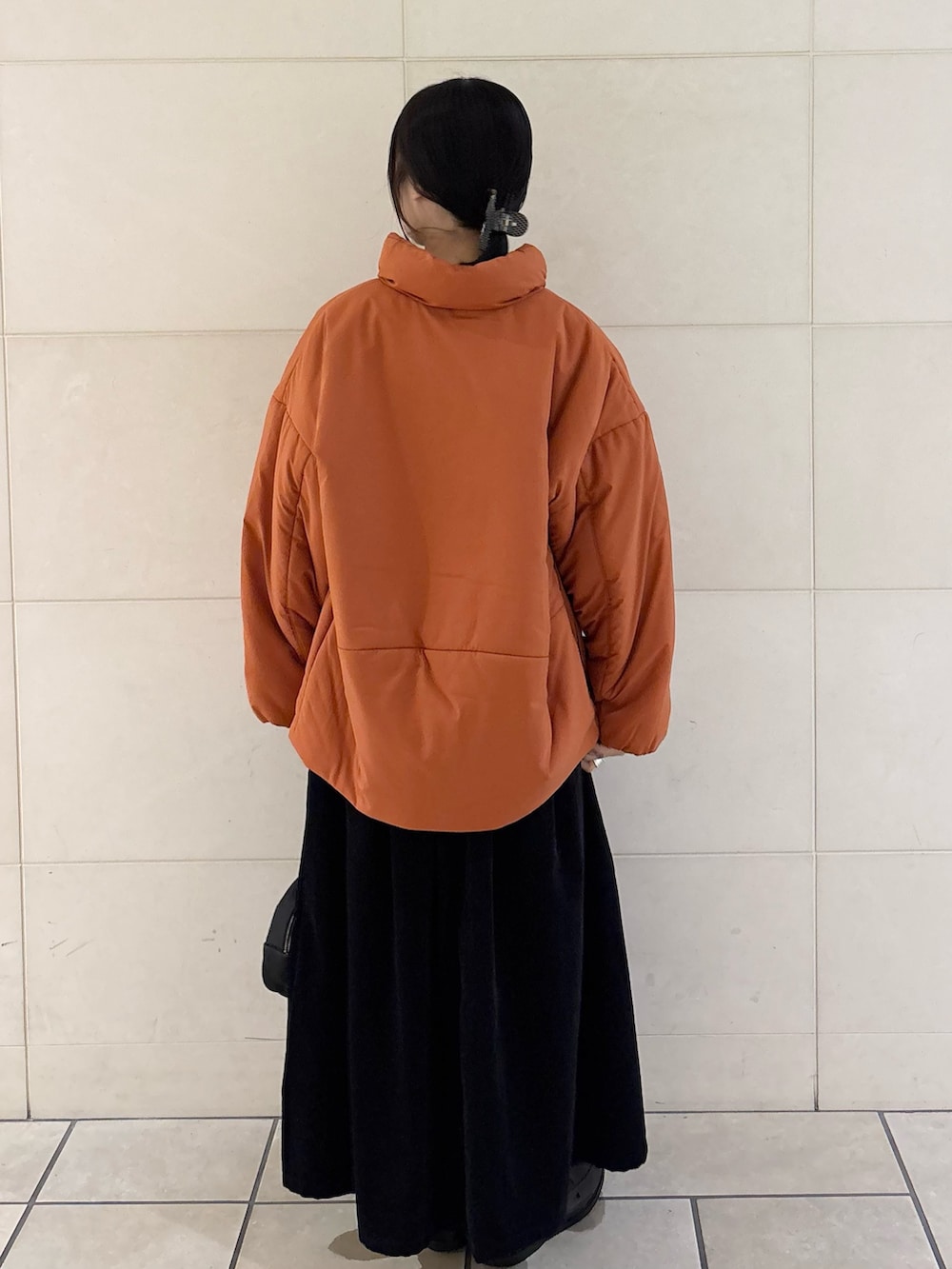 オレンジ系のブルゾン、グレー系のスカート、ブラック系のボストンバッグを着用したレディースの秋コーディネートの4枚目の写真