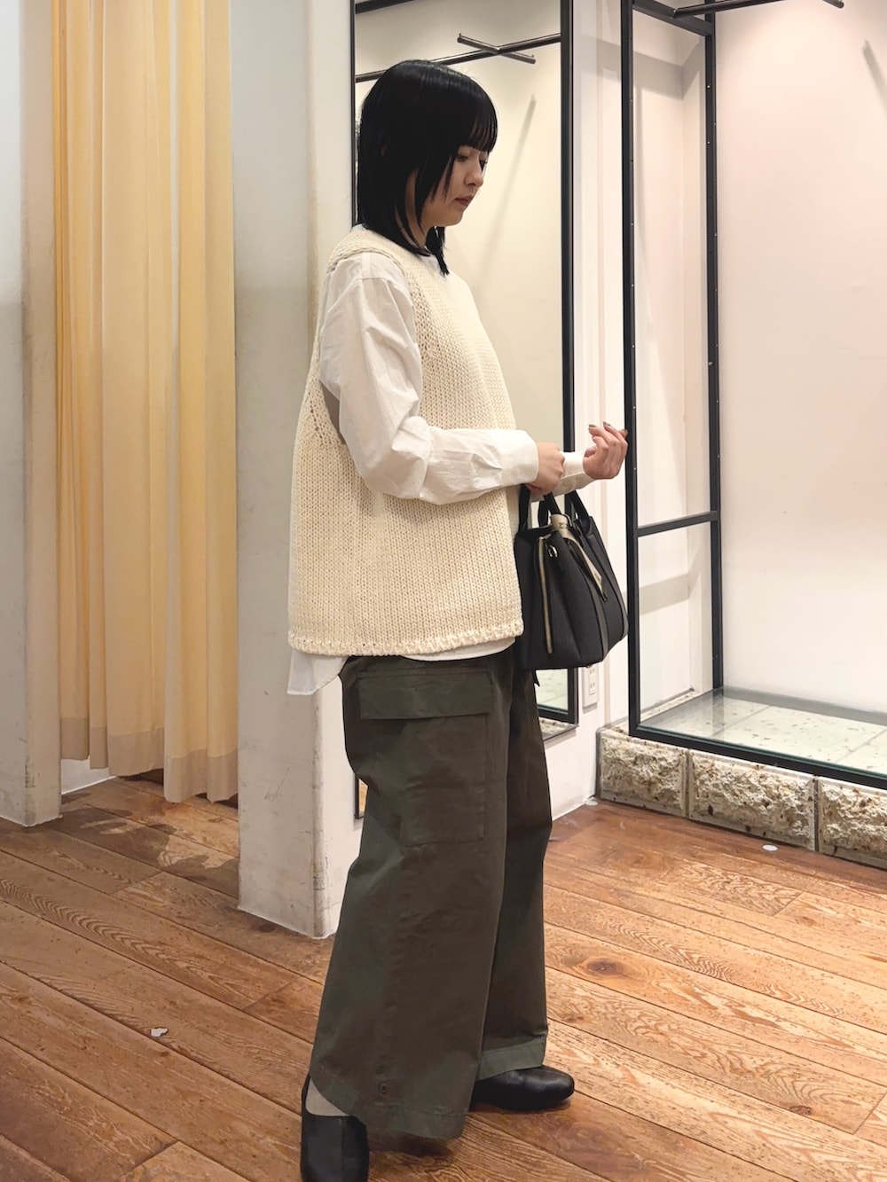 グリーン系のその他パンツ、ブラック系のハンドバッグ、ホワイト系のシャツ/ブラウスを着用したレディースの冬コーディネートの4枚目の写真