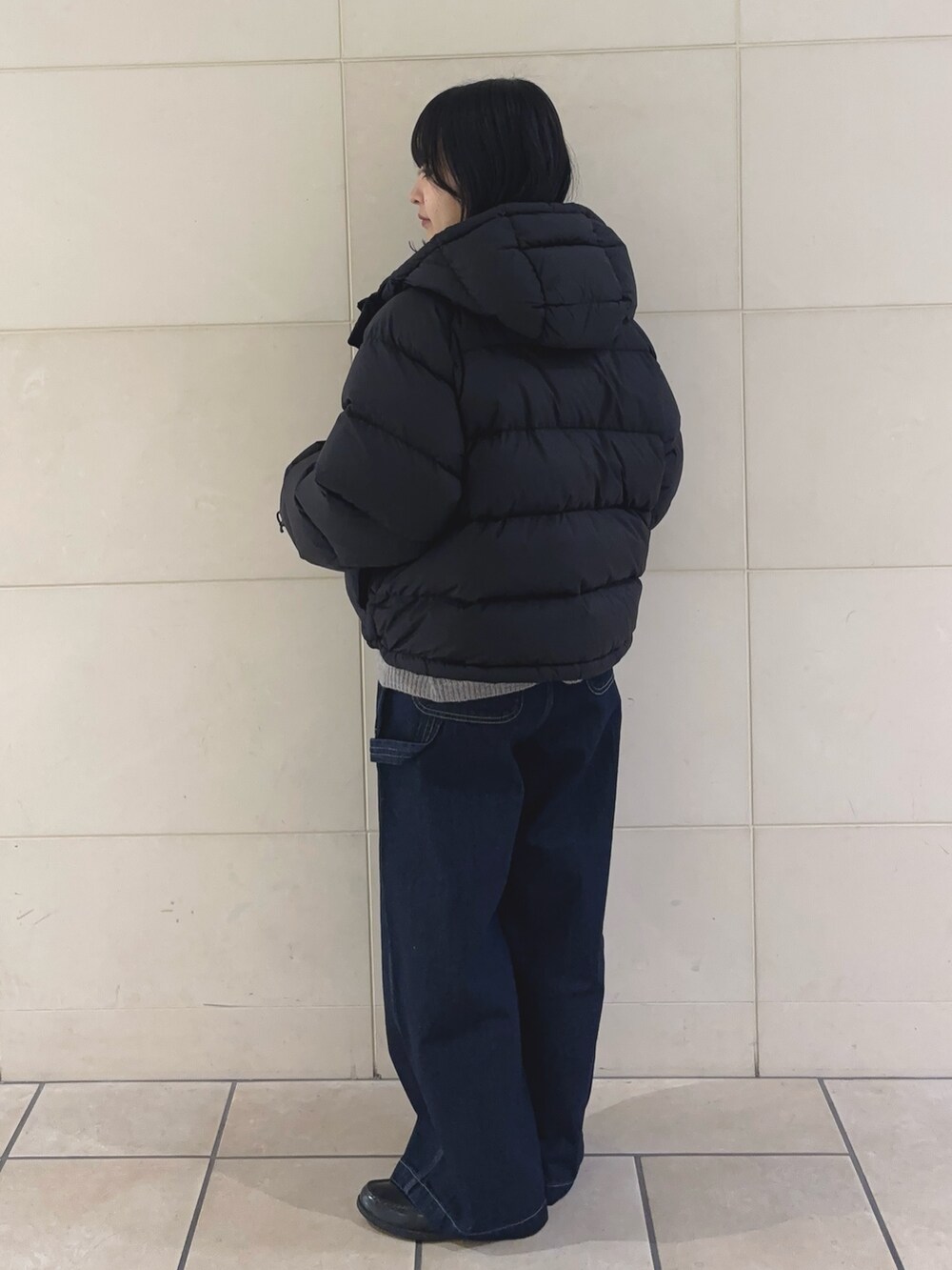 ブルー系のその他パンツ、グレー系のニット/セーター、ブラック系のダウンジャケット/コートを着用したレディースの冬コーディネートの4枚目の写真