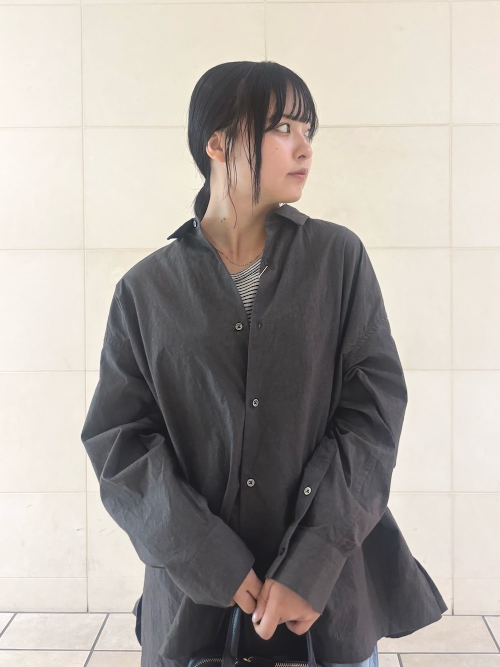 ブルー系のデニムパンツ、ブラック系のパンプスを着用したレディースの秋コーディネートの6枚目の写真