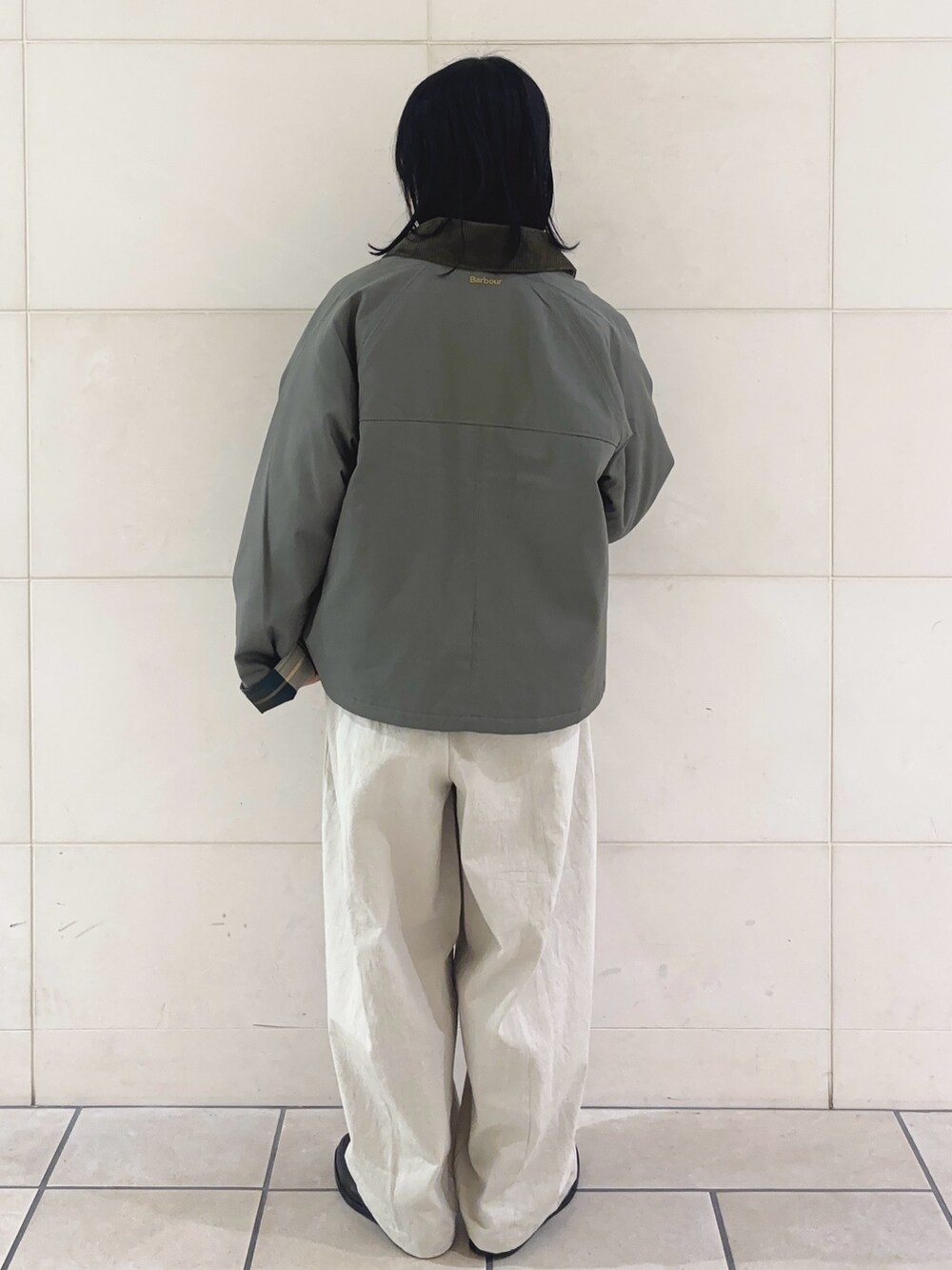 レッド系のニット/セーター、グリーン系のブルゾン、ホワイト系のその他パンツを着用したレディースの冬コーディネートの4枚目の写真