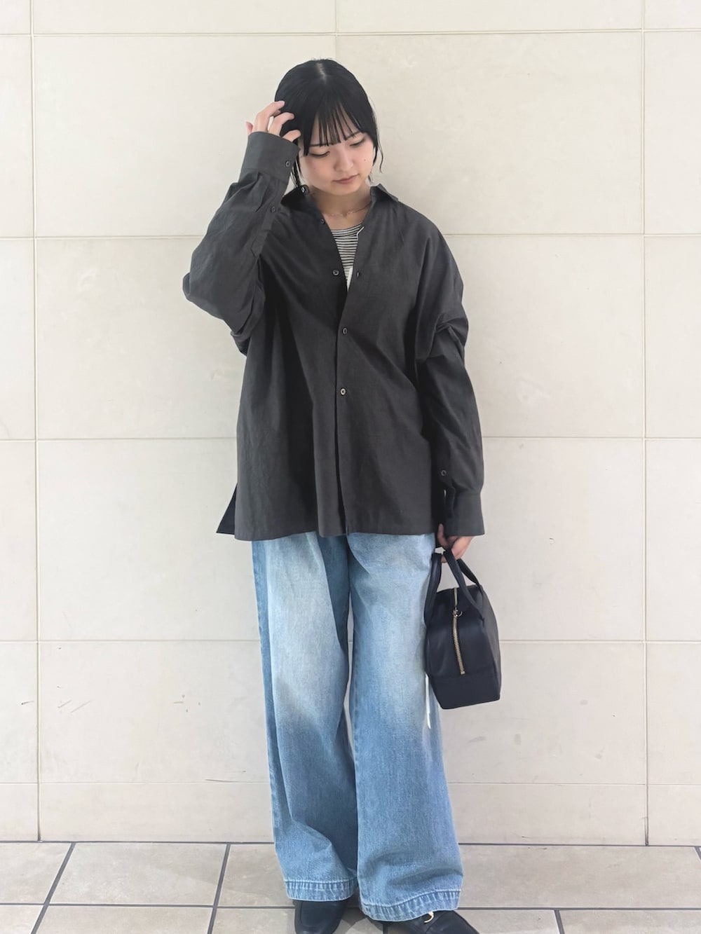 ブルー系のデニムパンツ、ブラック系のパンプスを着用したレディースの秋コーディネートの5枚目の写真